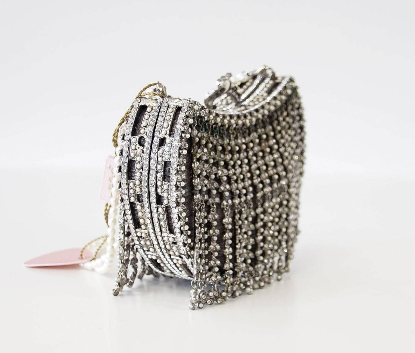 Guaranteed authentic EDIDI exquisite hand made demilune bag adorned with approximately 2000 crystals and pearls evening bag.
The diamantes and pearls fall in strands creating a fringe effect.
Underneath the fringe is a finely textured mesh like