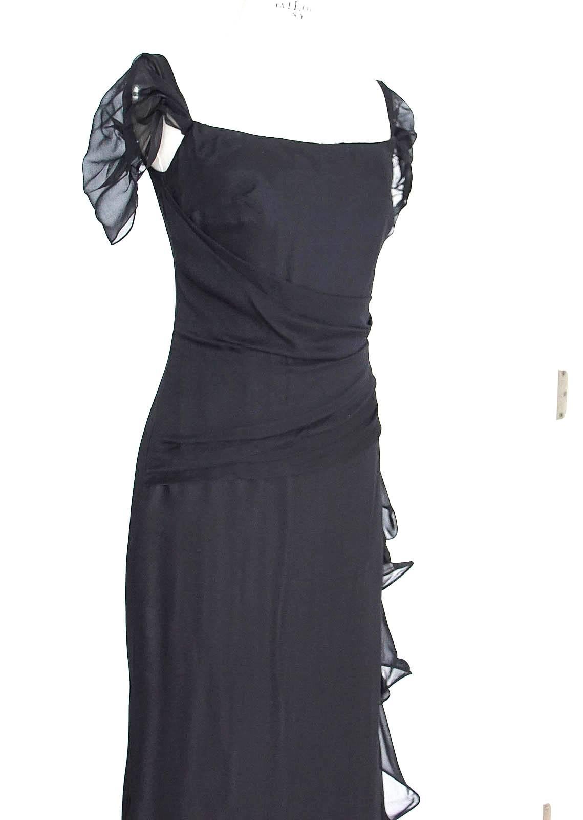 Guaranteed authentic Oscar de la Renta sophisticated and chic black silk chiffon evening gown.
Jet black silk chiffon dress.
Gently draping sheer chiffon cap sleeves.
In front fabric is softly rouched and angled towards the rear.
Interior has built