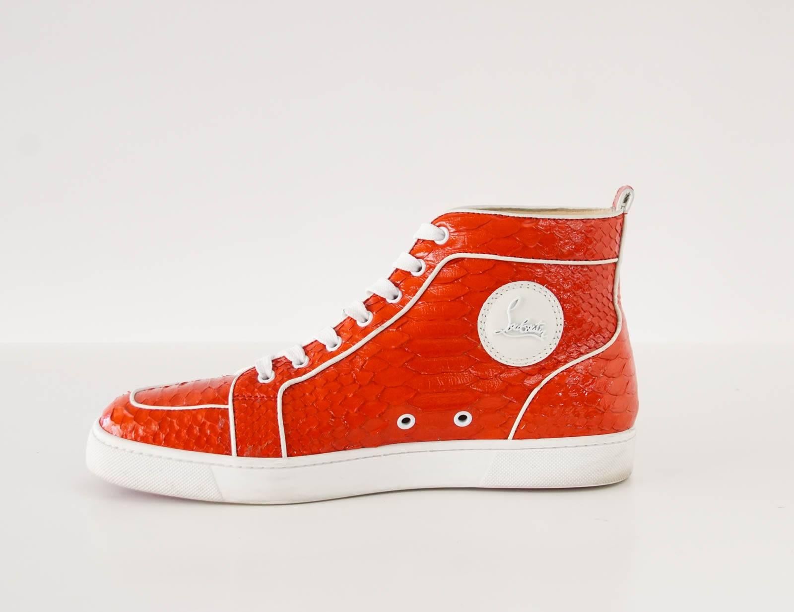 Guaranteed authentic CHRISTIAN LOUBOUTIN men's Rantus Orlato red snakeskin sneaker. 
Hightop sneaker accentuated with white piping trim.
Comes with box.
Logo plaque on side of shoe.
final sale

SIZE 43
USA SIZE 10

CONDITION:
MINT