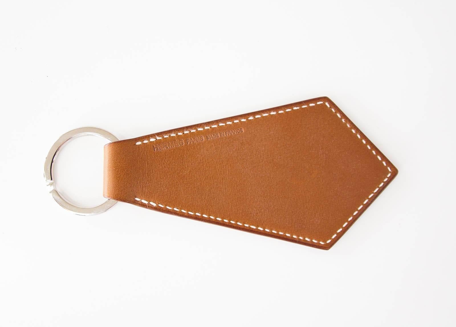Guaranteed authentic HERMES Super Lucky Charms Tab.
Tie shaped key ring in coveted Barenia leather.
Various detailed Lucky Charm etchings in the leather.
Signature HERMES PARIS Made in France is stamped on reverse side.
NEW or NEVER WORN.  Comes