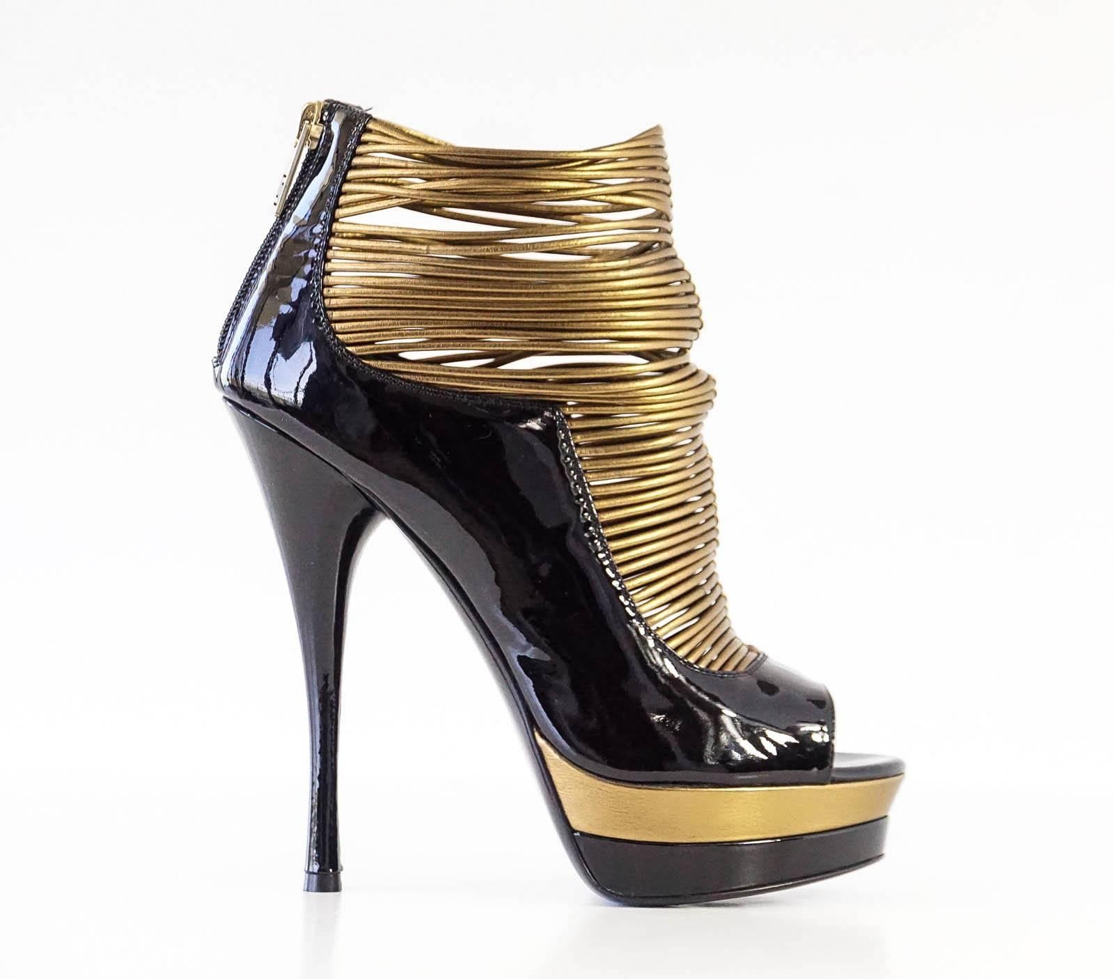 Guaranteed authentic VERSACE dramatic gold and black patent leather platform bootie style shoe. 
Peeptoe black patent leather bootie with thin rolled gold leather bands up the front foot.
Platform is accentuated in both both black and gold.
Rear zip