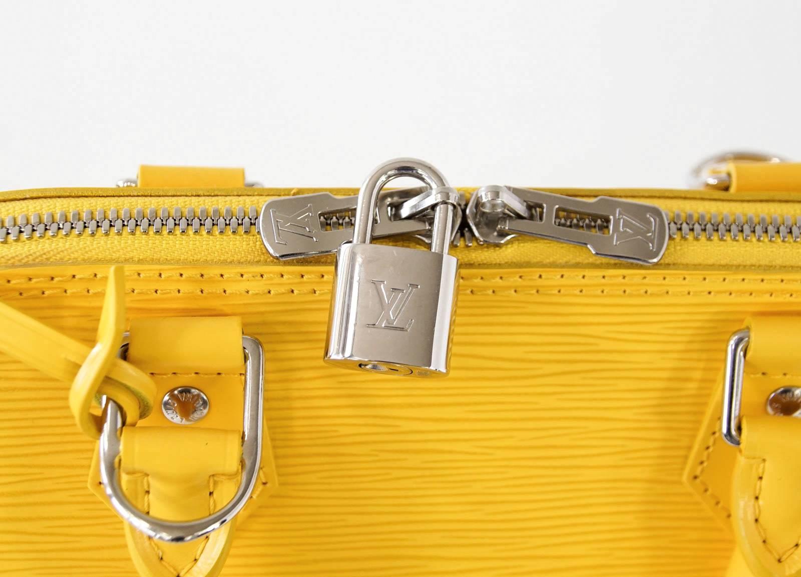 Guaranteed authentic LOUIS VUITTON classic Alma in vivid citron yellow
Silver hardware.
Top double zip with logo embossed pull.
Includes embossed lock and clochette with key.
Interior lined in yellow suede with slot pocket and cutout for cell