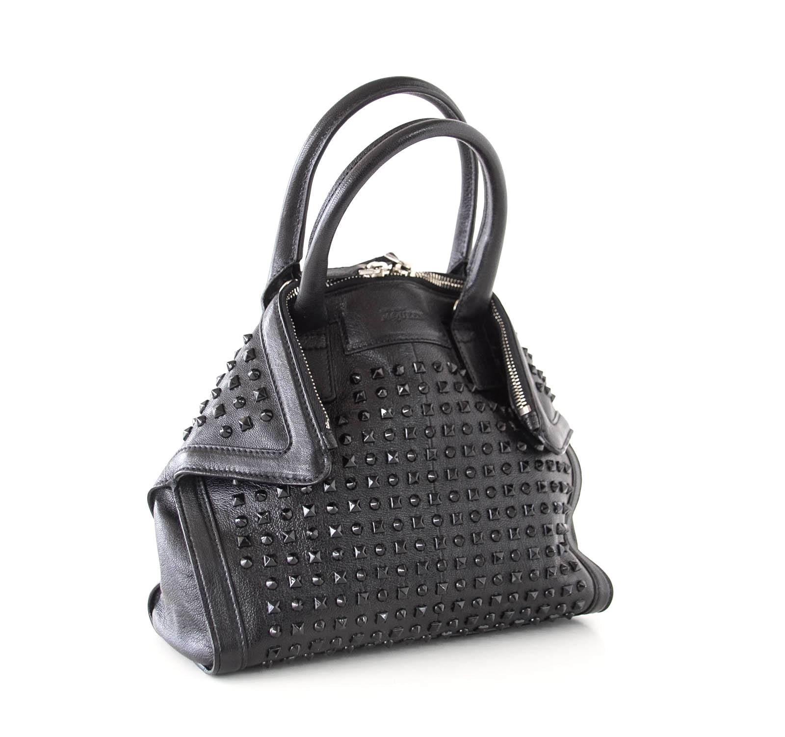 Guaranteed authentic ALEXANDER MCQUEEN black De Manta tote.
Chic black on black studded bag with double top zip.
Bag edges fold over hidden magnetic tabs.
Detachable shoulder straps add versatility as a shoulder or crossbody bag.
Interior zip