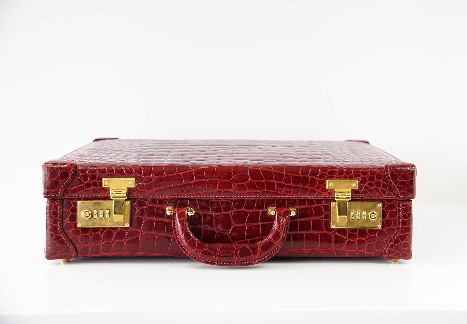 Guaranteed authentic exquisite Gucci vintage jewel toned deep red crocodile briefcase.
GG studs next to combination lock. 
Interior is lined in a tobacco quilted pigskin leather.
2 large leather portfolio styled pockets. 
Comes with luggage