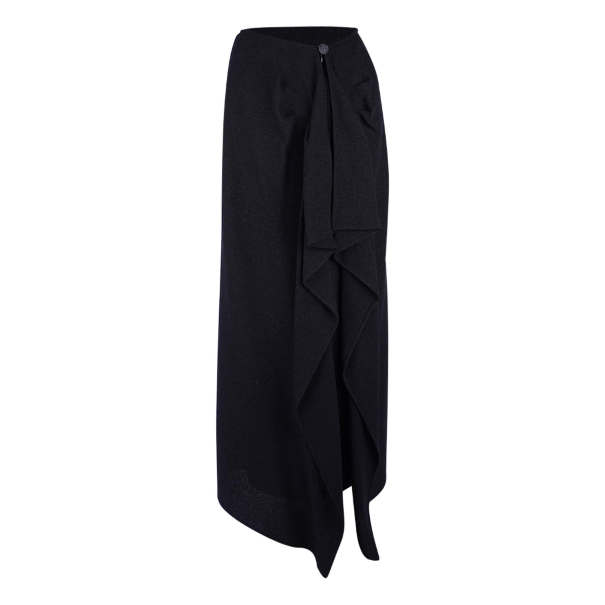 Guaranteed authentic Chanel 98A unique skirt.
Utterly divine.
Jet black long wool skirt that is cut in a very subtle A line and simple in the front.
The waist has a small silver metal plaque embossed Chanel.  Very subtle. 
The story of this amazing