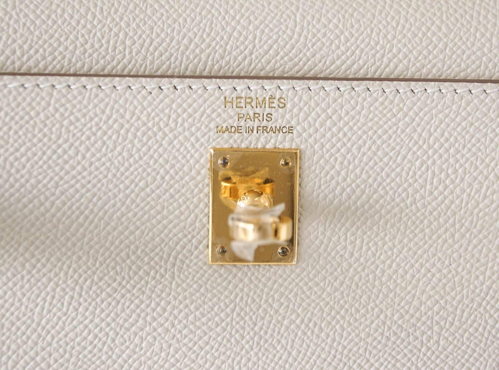 Guaranteed authentic 25 Hermes Kelly Sellier in creamy neutral perfection - Craie.
Created in Epsom leather.
Rich with Gold hardware.  
Accompanied by new matching Hermes Twilly Colliers de Chien  in Orange, Coral and Indigo with Hermes orange