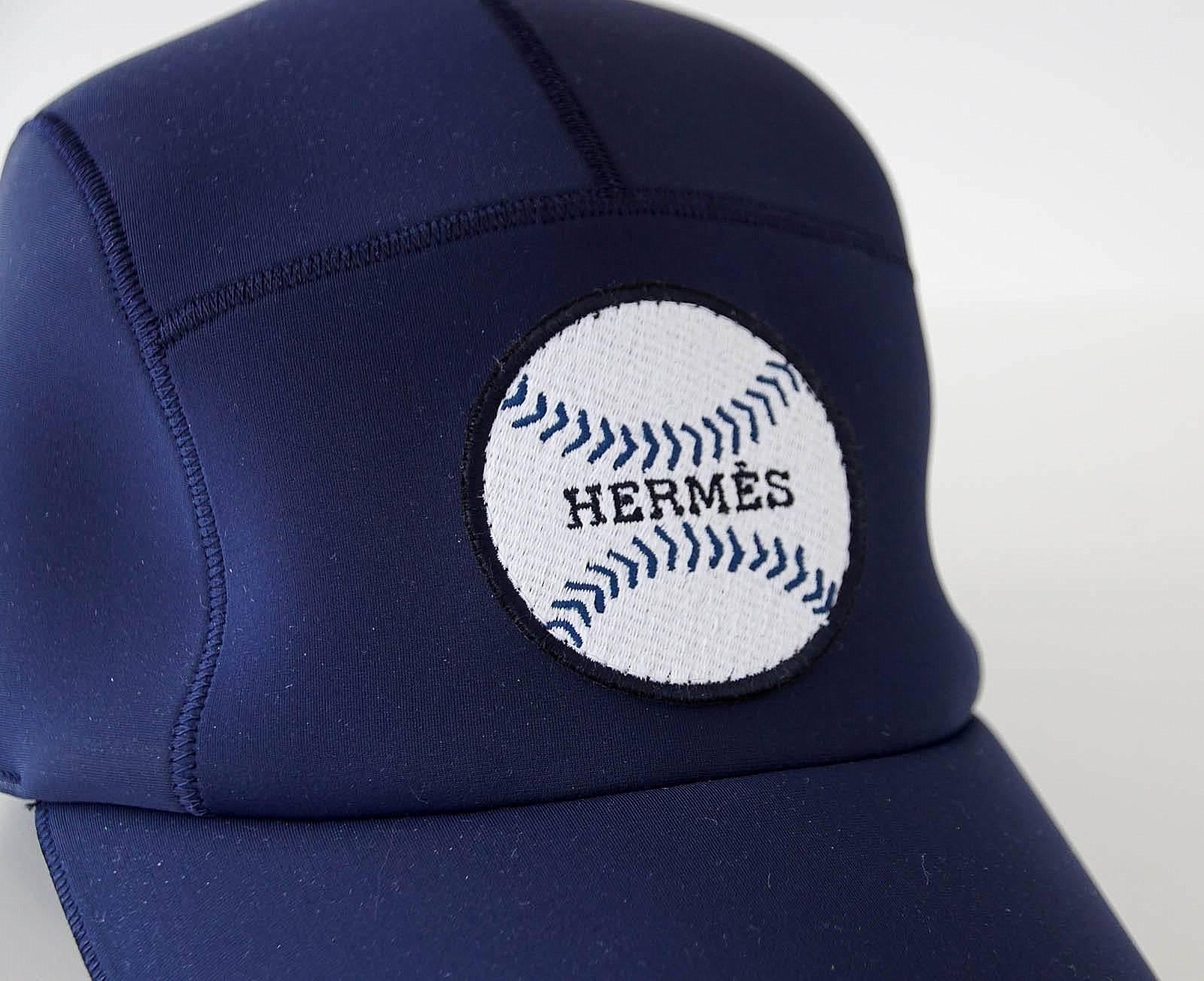 Guaranteed authentic Hermes Limited Edition Sold Out navy blue Baseball cap.  
The cap shows a white Baseball with navy stitching and HERMES written across the center.
2 HERMES PARIS Clou de Selle snaps at rear. 
NEW or NEVER WORN
2 identical caps