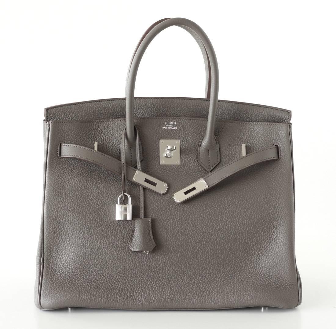 Guaranteed authentic exquisite Hermes Birkin 35 Etain bag is the most perfect medium gray and is utterly neutral. 
This beauty is absolutely stunning with palladium hardware. 
Clemence leather is textured and highly scratch resistant.
Comes with