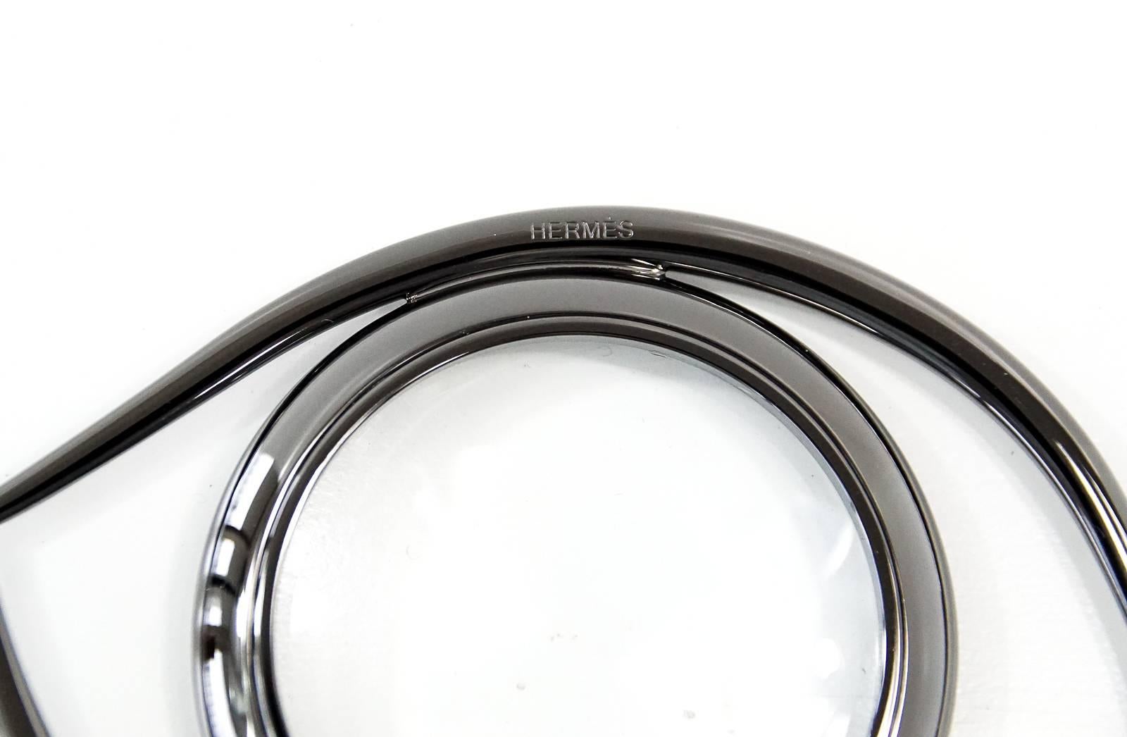 Guaranteed authentic Hermes Eye of Cleopatra magnifying glass / paperweight in ruthenium finished brass.
Beautiful blend of form and function, originally designed in the 60's by renowned 
French writer and film maker Jean Cocteau.
Comes with