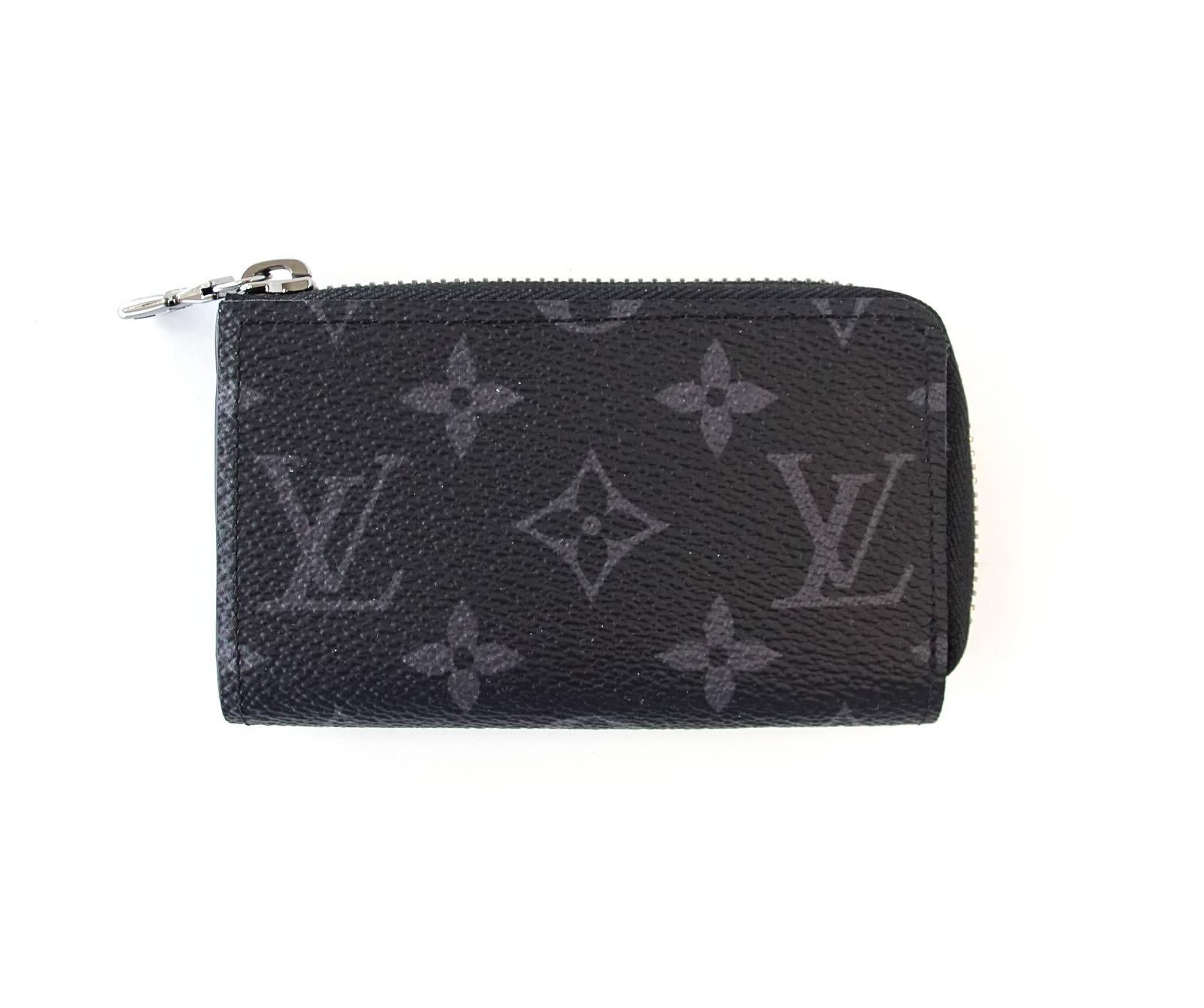 Guaranteed authentic Louis Vuitton black and gray Car Key Case.
Holder zips around top and side.
Case has inside slot and leather strap to attach keys.
Black background with gray monogram.
Comes with Louis Vuitton sleeper and box.
NEW or NEVER