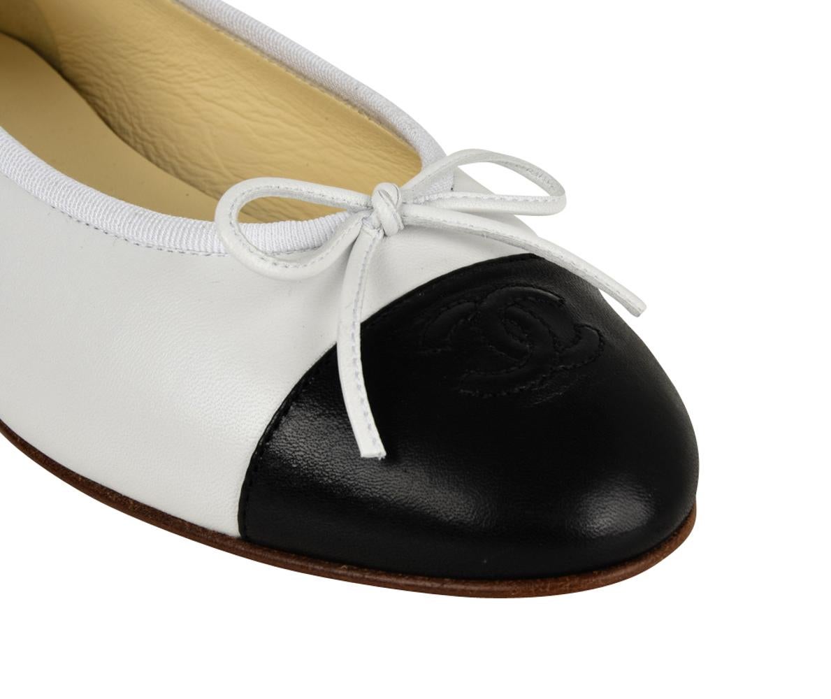 Guaranteed authentic Chanel classic leather 2-tone ballet flat shoes in white with black toe cap. 
Signature CC and bow over toe.
Edged in white grosgrain.     
Comes with box and sleeper.
NEW or NEVER WORN
Same shoe available in gray and black