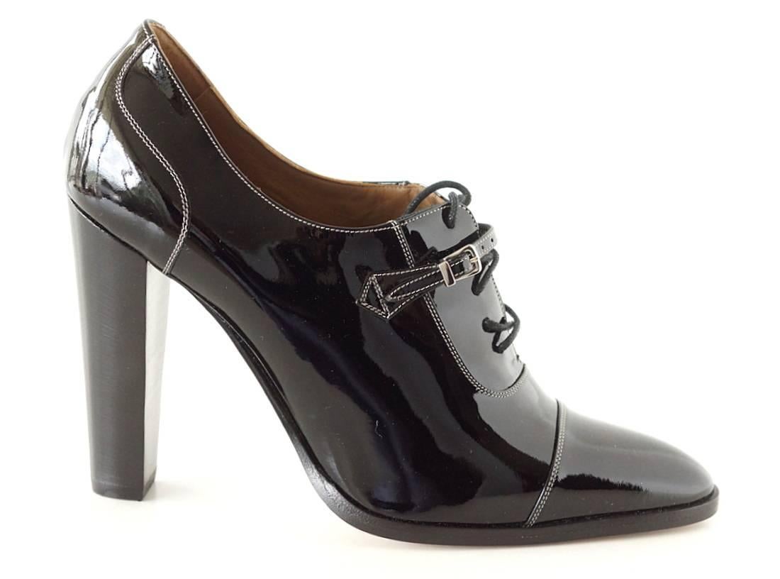Guaranteed authentic Hermes jet black patent leather pump. 
Lace up with thin tab and silver buckle detail.
Fine white top stitch detailing. 
New or Never Worn.  
Final Sale

SIZE 38.5
USA SIZE 8.5

SHOE MEASURES:
Inner (upper) Sole  10"
Heel
