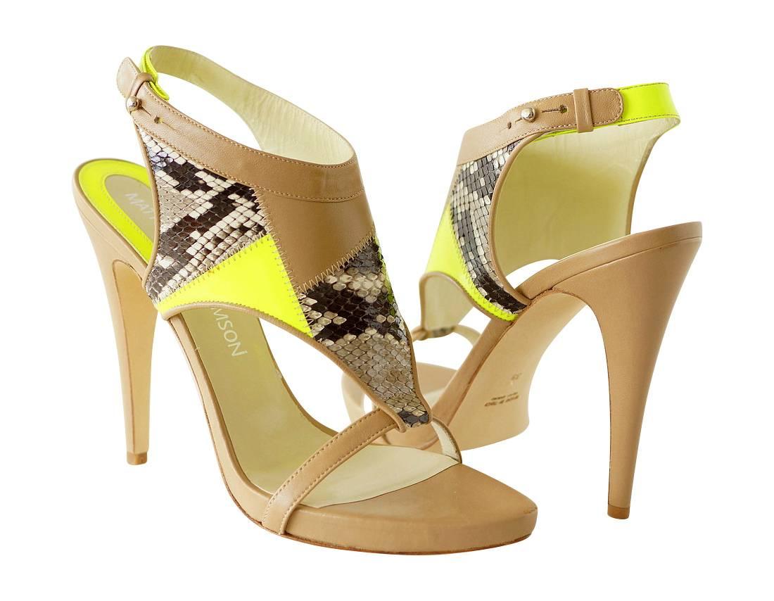 Beautifully shaped wide front T-strap.
The unique design is created by patches of snakeskin, neon green patent leather and nude calf leather all stitched together by zig-zag stitching.
Strap around the rear of the ankle has large silver grommet