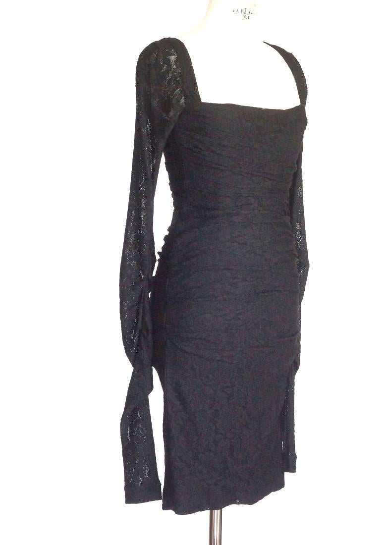 Guaranteed authentic DOLCE&GABBANA striking cocktail dress. 
Body conscious rouched for flattering angles in rich jet black lacy knit.
Squared neckline in front with sleeves that come to edge of the shoulders.
Bodice is boned all
