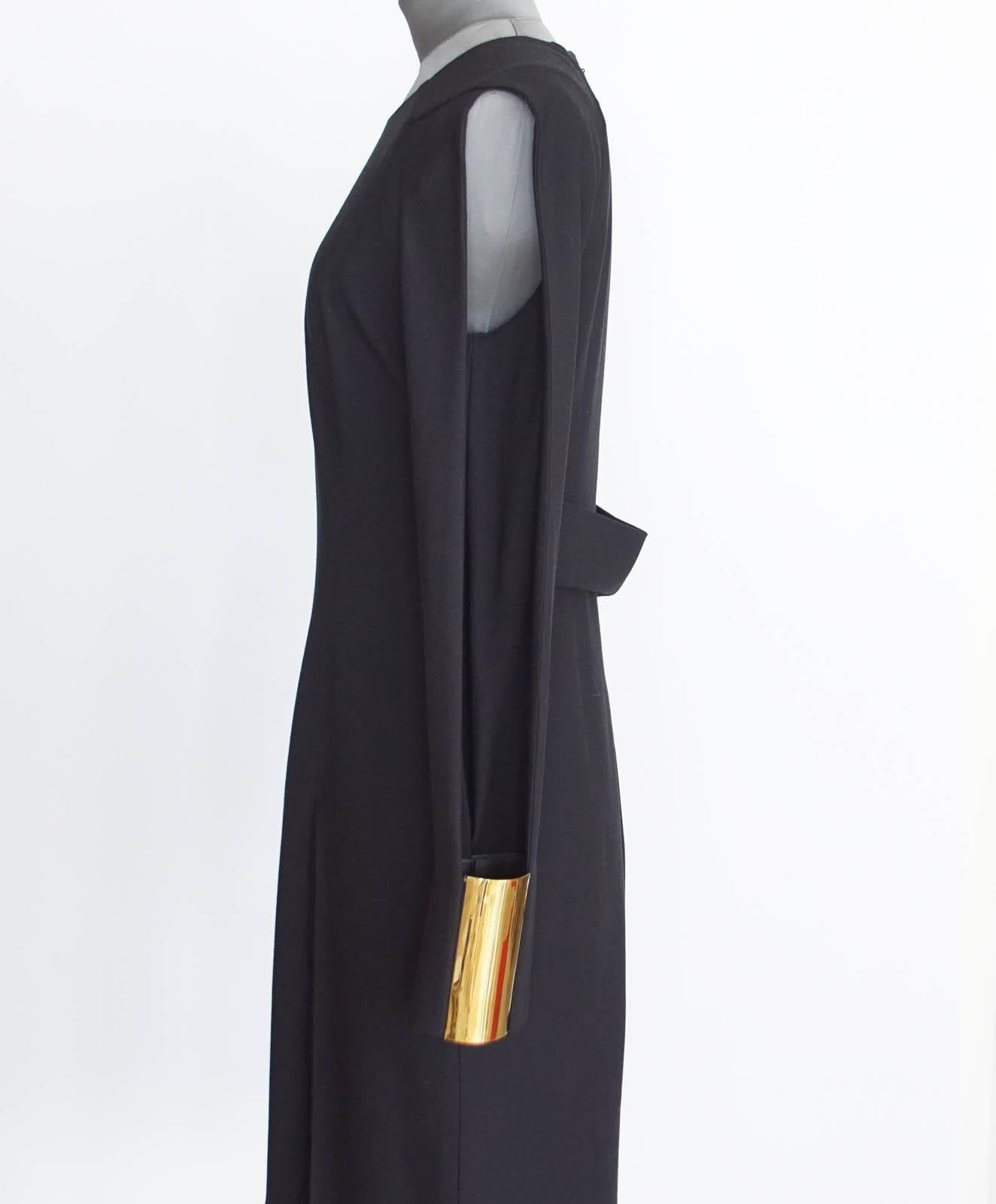 Striking Gucci long sleeve fitted black dress with a high round neck.
Sleeves are cut open from the shoulder to the wrist on the outside with a 4.5