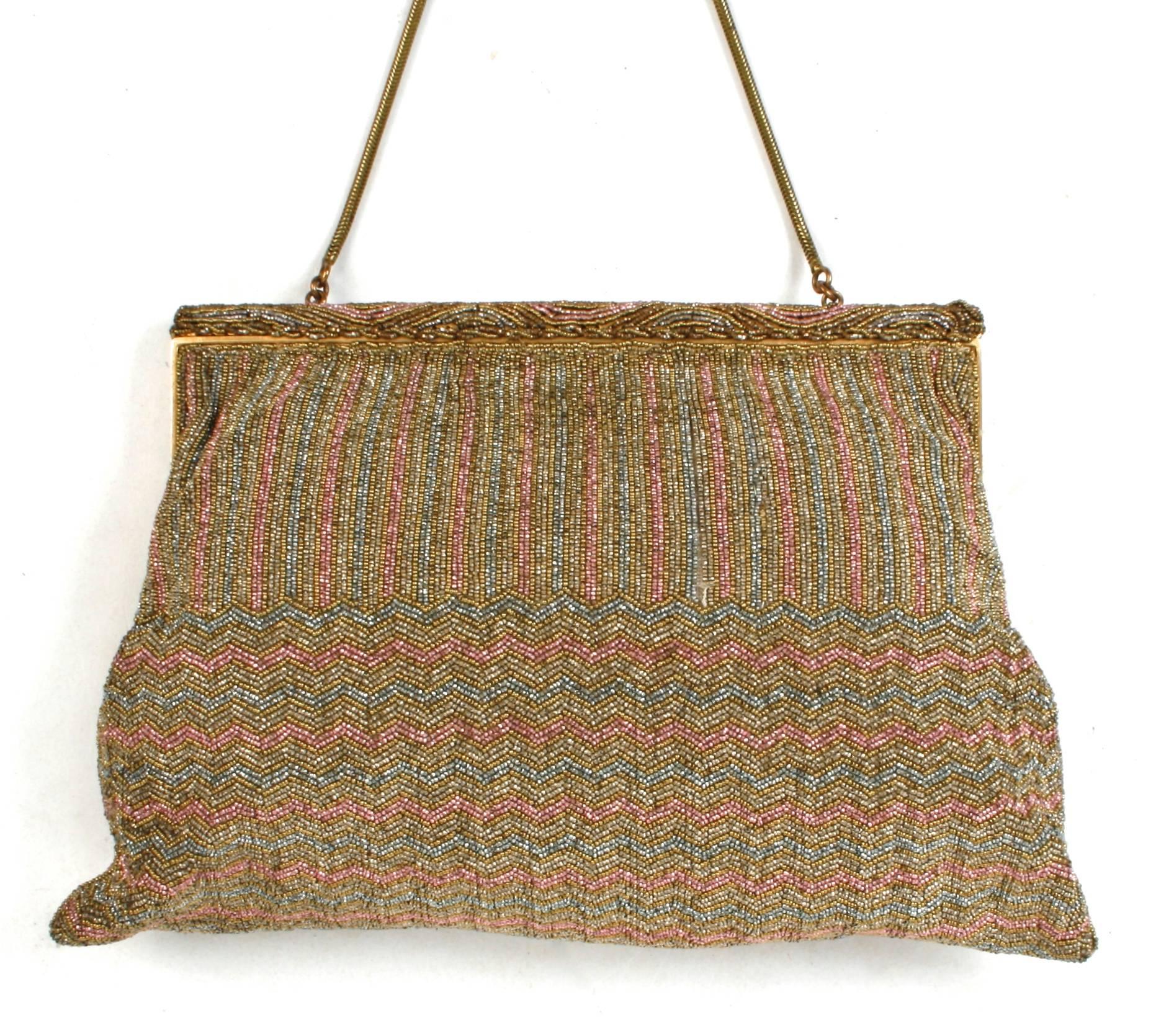 Very fine micro beaded evening bag in a striped and zig zag pattern. Beads are copper, gold and silver. It has a gold-tone metal hinged frame with a wave beaded top band.  Purse has a 12'' gold-tone snake chain handle and a hinged and beaded button