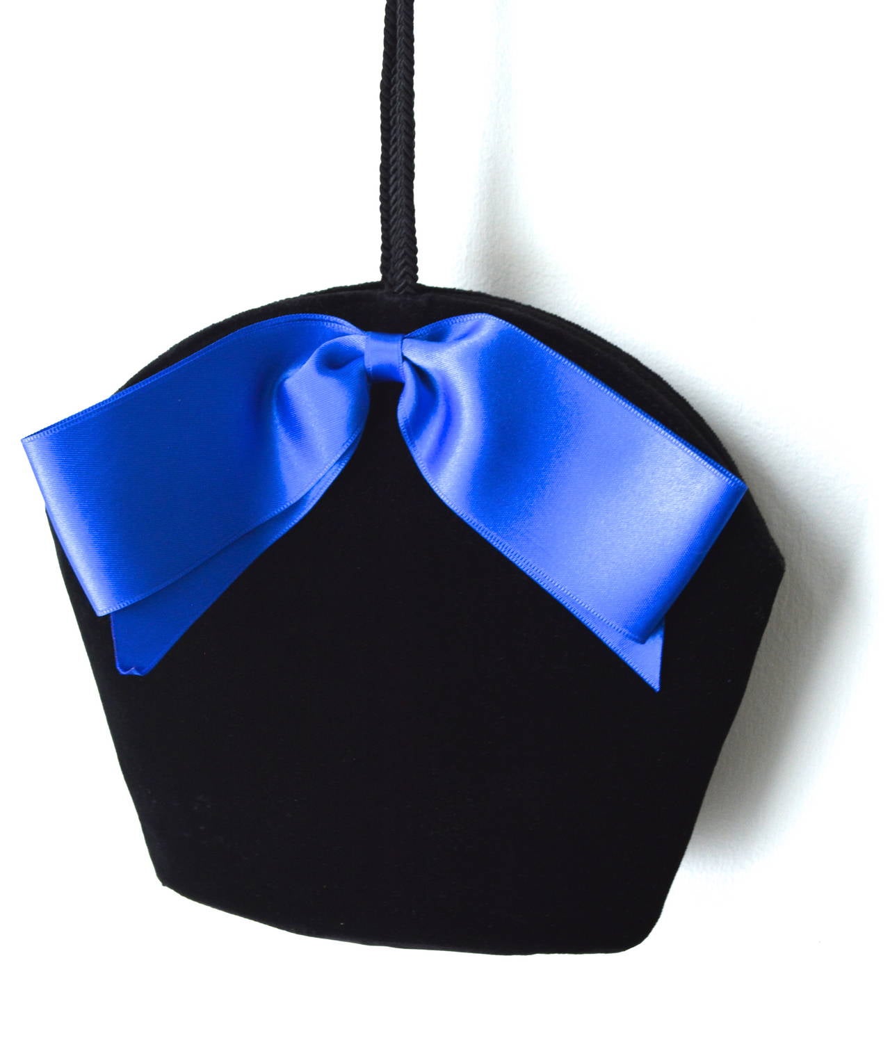 This lush blue bow and soft velvet vintage YSL bag is a rare find, authentic and has the Yves Saint Laurent, made in France plaque inside. Circa 1970s-early 80s. Dating most likely from 1976-77. It's combination of black velvet and a bow can be seen