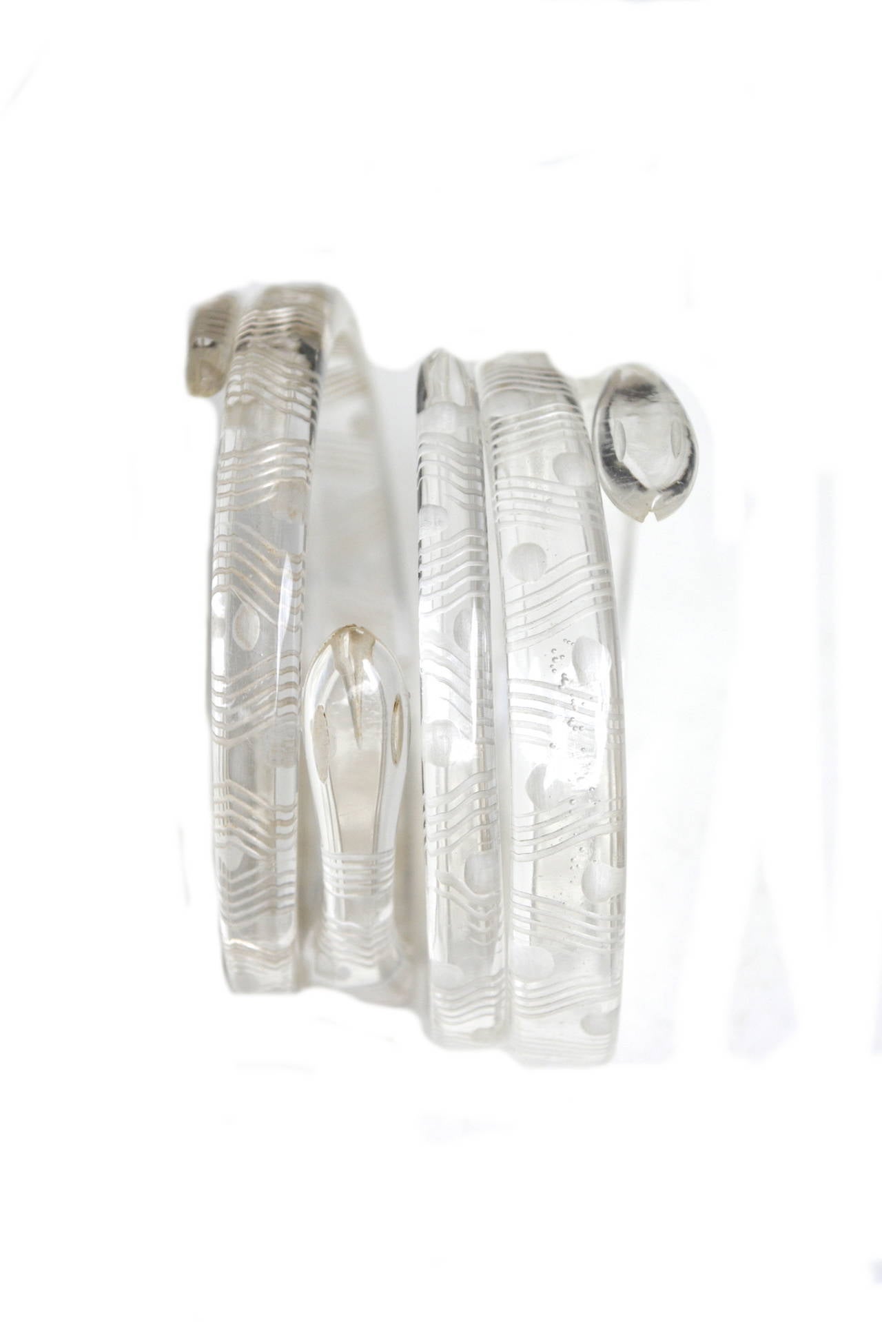Fantastic 1920s-30s carved clear celluloid or lucite acrylic snake cuffs. Lucite was invented in 1931 by the Dupont company and these could be early lucite.  They feature carved heads, polka dots and wavy lines. Crisp and clear with minimal to no