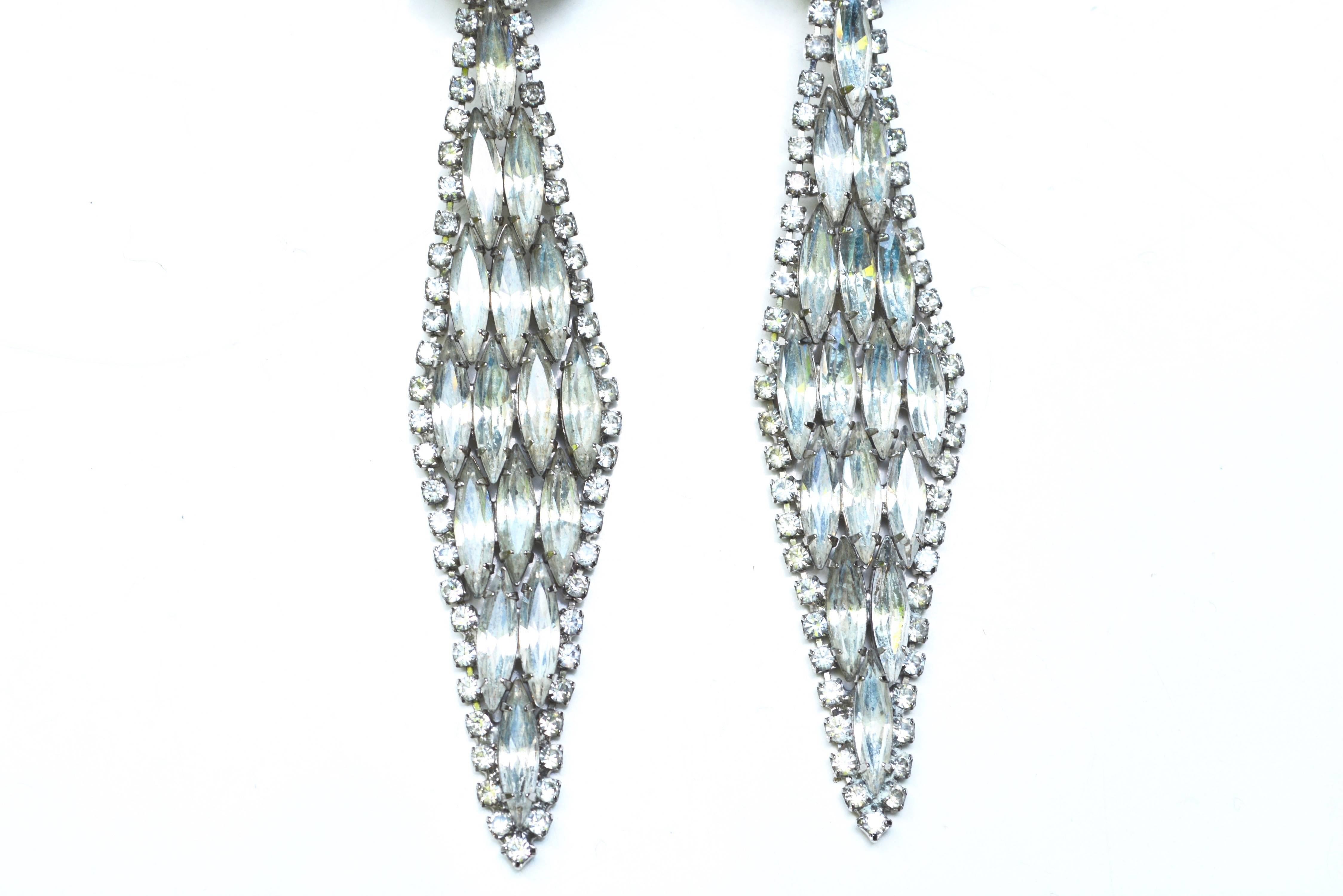 Glam large elongated diamond style clip on earrings, not signed. Good condition to wear, but there are a couple darkened stones on the circular clips. Some age to larger stones but nothing that takes away from the sparkle! 4.5″ long by about 1″