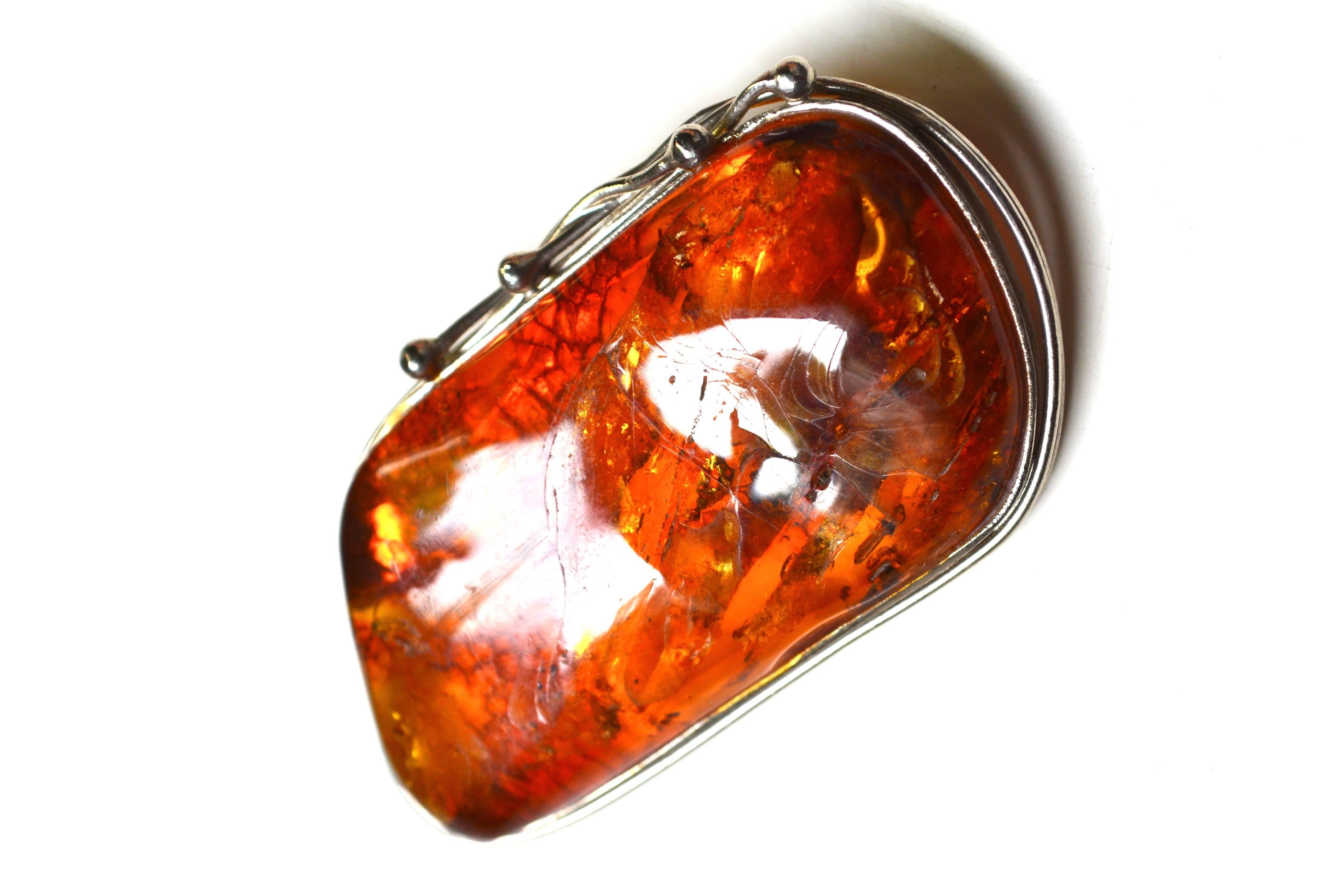 Early 1900s sterling amber larger antique amber brooch. About 2.25" long. The amber is in good condition with what appears to be natural views and cracks which have been shaped or smoothed.  Lovely color and size. Width is about 1.25". Due