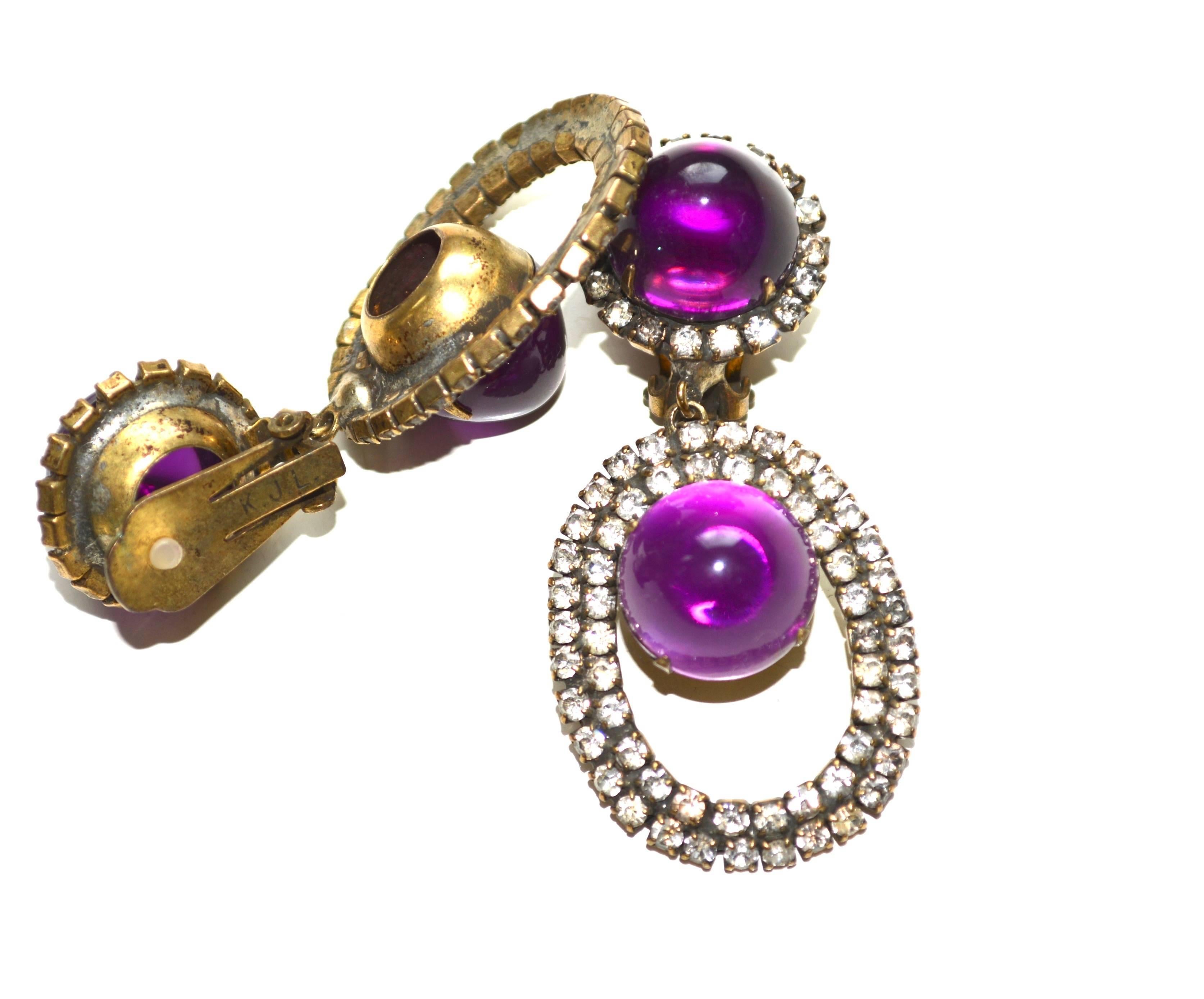 Marked K.J.L purple drop earrings in the classic shape, style, and construction Kenneth Jay Lane used in the 60s. Deep pretty color with rhinestone accents. The earrings are in good condition, but the rhinestones show age, with a few being dark as