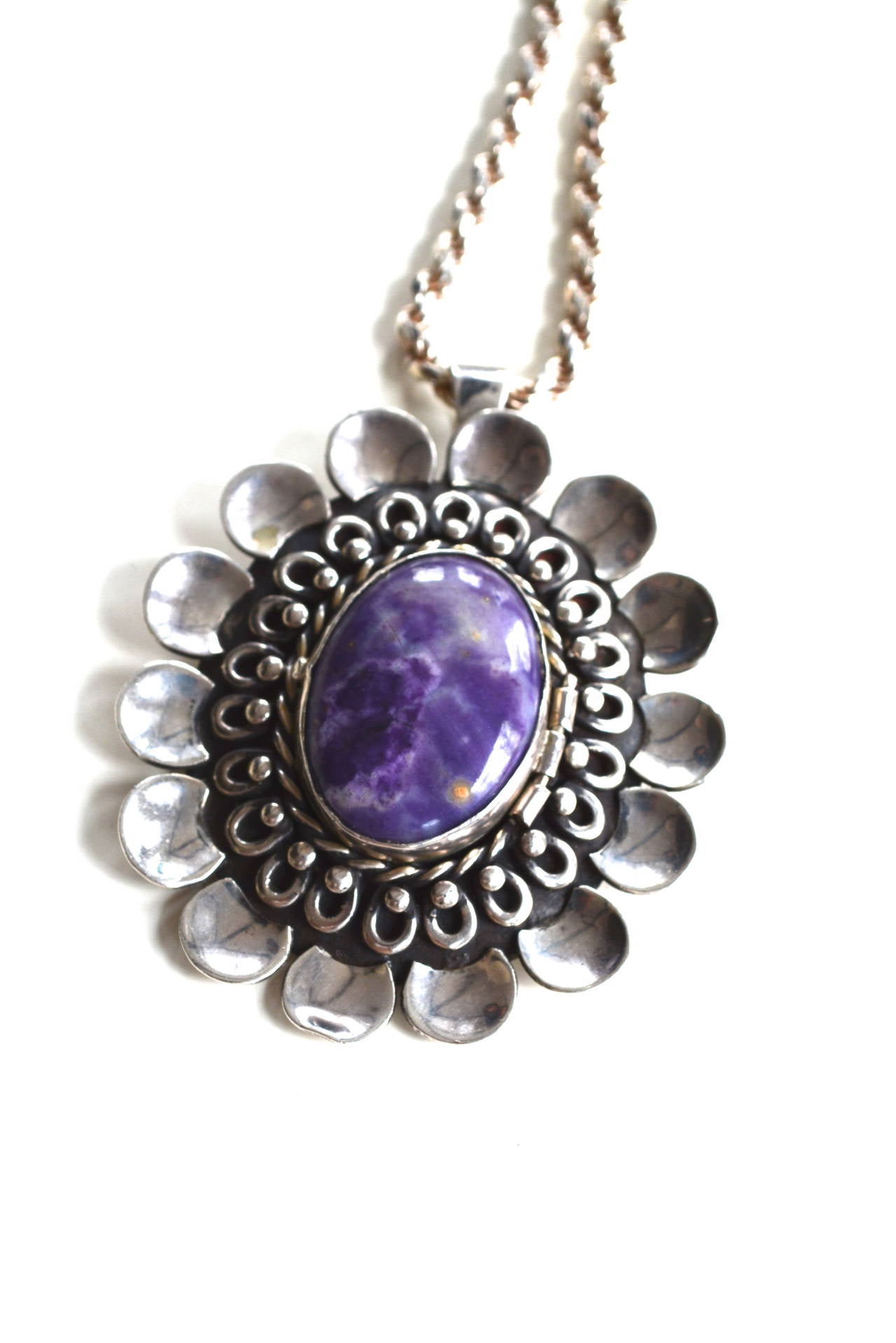 Large stylized purple agate sterling pendant by Los Ballesteros. Signed on the back Talleres de Los Ballesteros. Taxco. Sterling. 925. Hecho en Mexico. It has the B and eagle mark 47 which dates from the 1950s-1979/80. 
The iconic Los Ballesteros