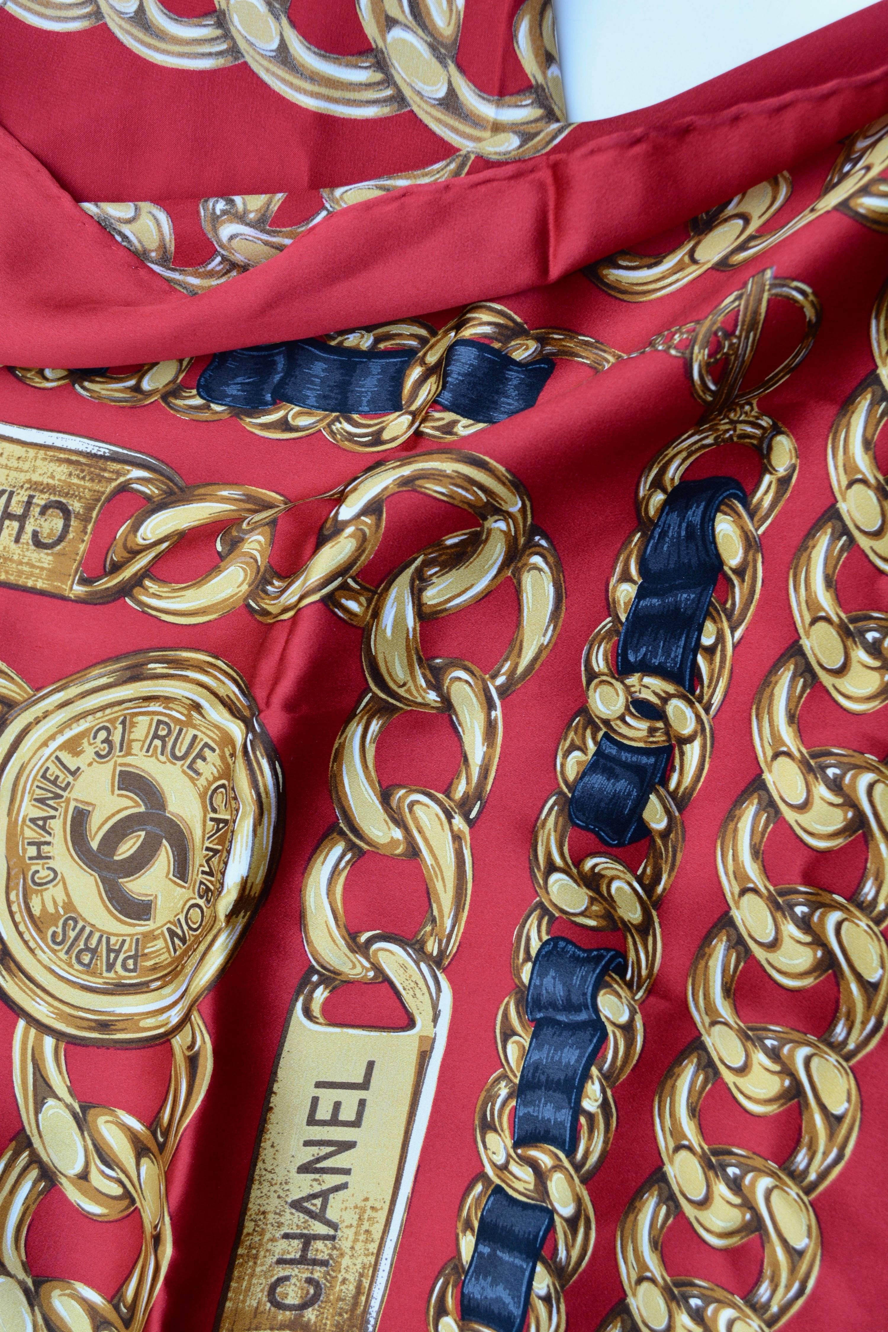 Red silk Chanel scarf, signed, tags removed. Iconic chain design.  Circa 1990s