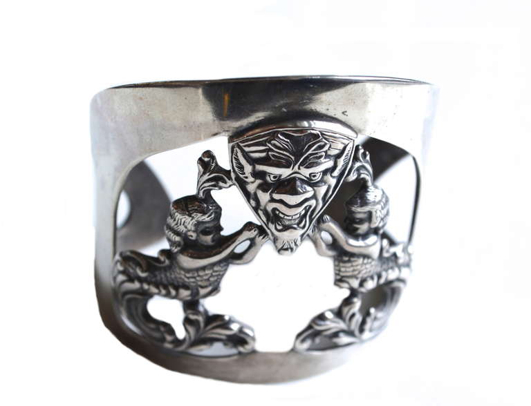 Vintage marked sterling cuff, featuring a large mask and two mermaids. The piece is similar to some Asian examples but is not signed. Larger scale, graduated design.  5.5″ with a 1.25″ opening. Fits a 6″ wrist well. Lovely design and aged patina.