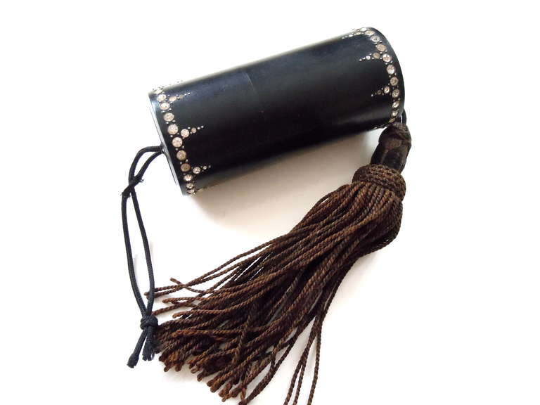 20s French black celluloid and paste stone vanity or party purse used to bring only the essentials to a flapper filled event or party.  Wonderful paste stone design and canister shape. The long tassel has kind of a chocolate brown color to it. This