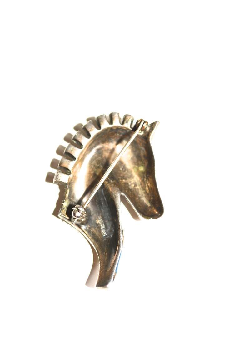 Fanciful art deco sterling horse brooch with enamel details and paste stone accents. Marked: Sterling.