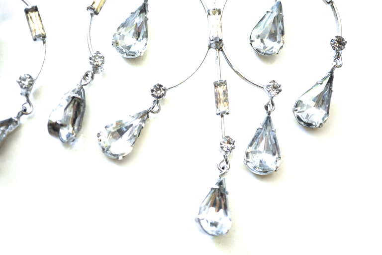 Oversized metal work and glass drop chandelier earrings from the 1960s. Clip on style. Light weight enough to wear well. Movement and sparkle remain in good condition. Unsigned. Total length from clip to dangle is 4