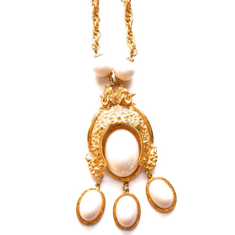 Creamy white signed Alice Caviness lucite and golden metal necklace. The design has a great scale and features two smaller coiled snakes at the top of the pendant. The pendant measures 5