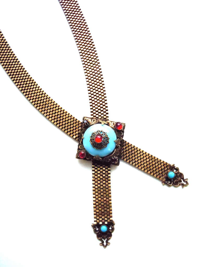 Victorian revival book chain style 1940s necklace with divine blue glass accents. This piece features gorgeous ruby glass details for drama.   I believe this to be a Selro piece.  The crossed chain is decorated with an Etruscan style medallion.  It