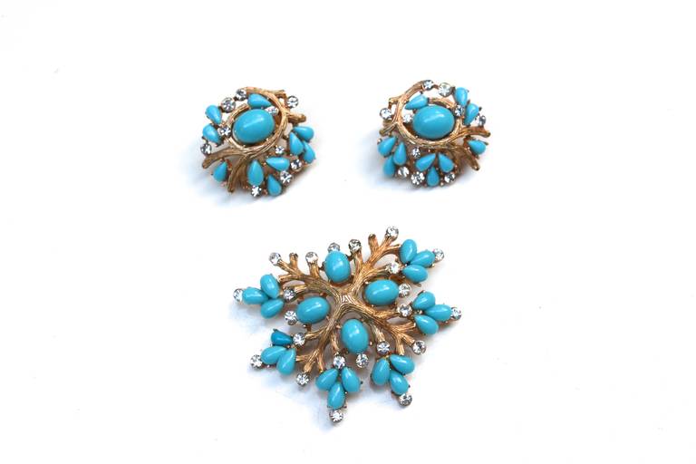 Lovely 1950s signed Trifari branchy coral style design flanked by vibrant turquoise lucite stones and rhinestones. Stunning color and design. Earrings measure 1″ and the brooch is 2″ long X 1.5″ wide.