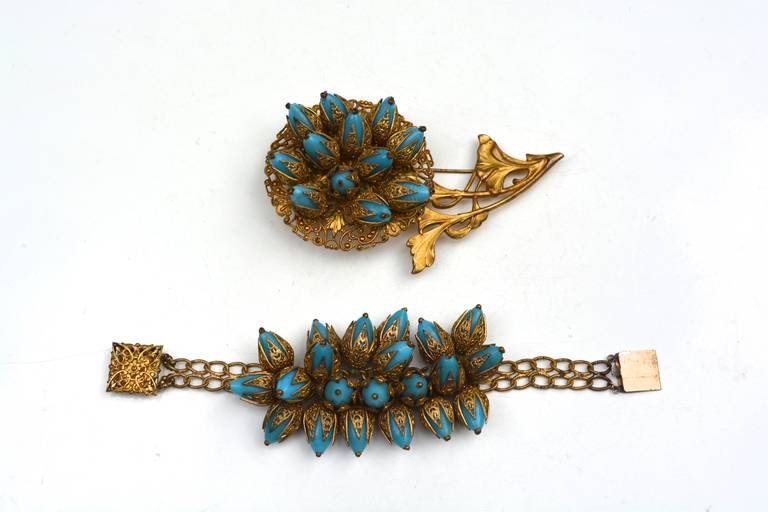 French signed blue glass and gilt metal fur clip and matching bracelet. Both pieces are detailed and unique. The blue glass beads could be gripoix.  The bracelet beads are strung on with thread. Since, they are loose I will reinforce them with new
