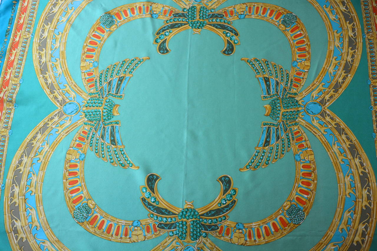 Vintage Must de Cartier vibrant turquoise and golden toned silk scarf with amazing winged scarabs. Lovely Egyptian revival design. Size 32 square. Very Good condition with minimal wear. I see one tiny mm dot in a corner. Color is great and condition