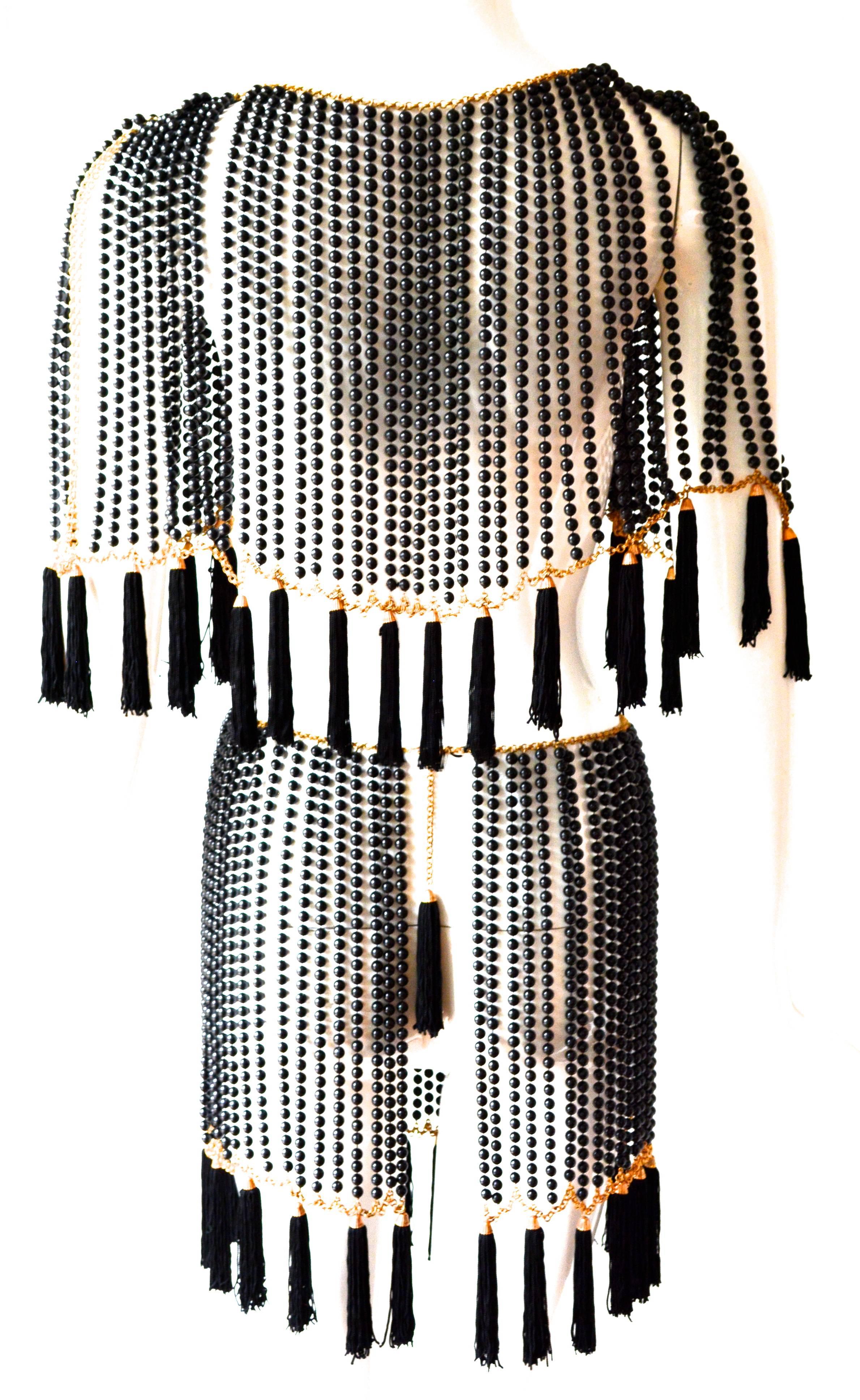 Incredible rare black bead and metal Bill Smith cape and skirt with silk tassel accents. One size. Can be used in a variety of ways as shown. The piece has a hook and tassel design which can be worn in the front or back.  The beads appear to be a