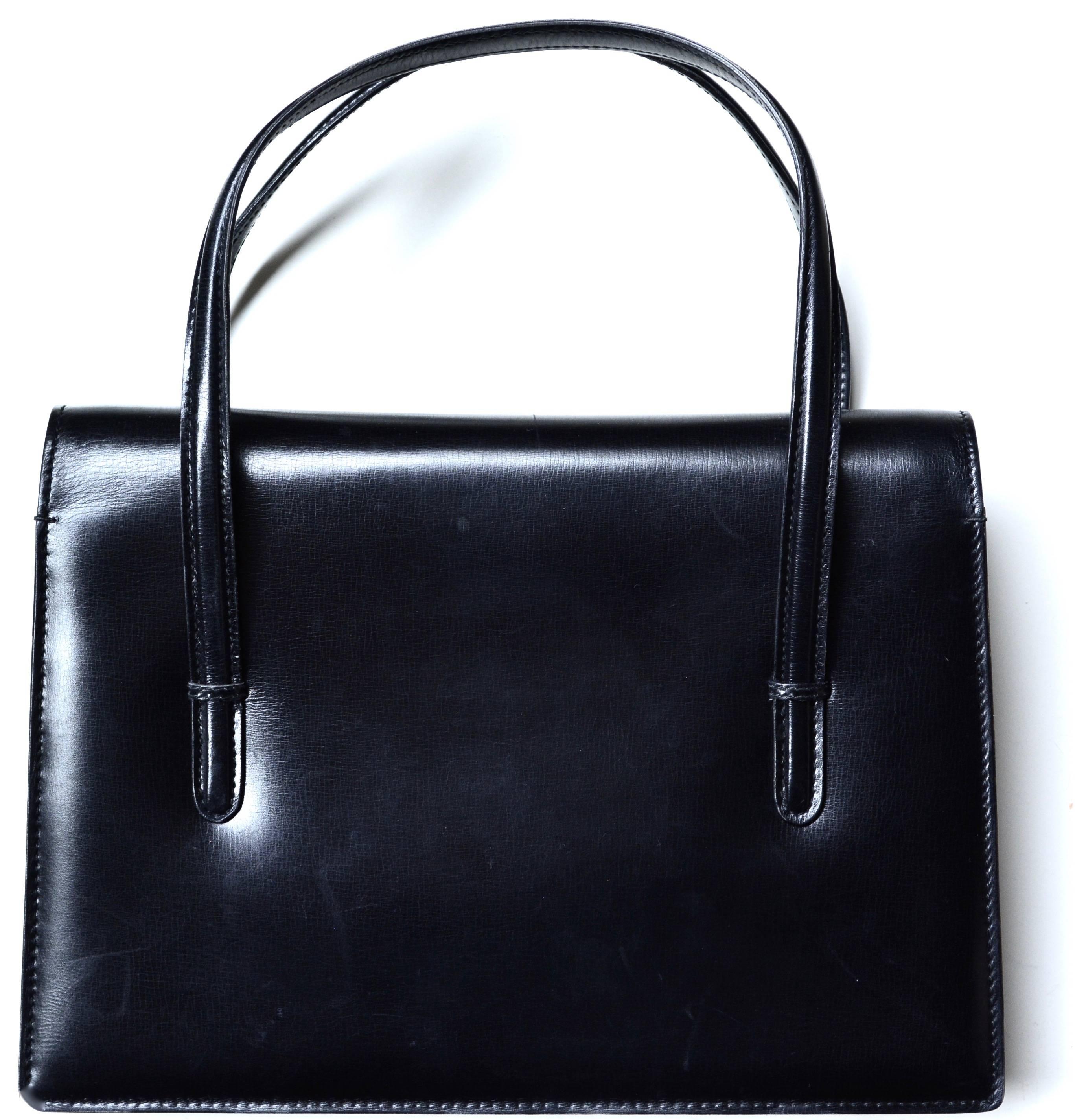 Signed Gucci soft, but structured black 1960s handbag. The bag is clean inside. Lovely classic design. Opens with a snap and has zip compartment inside. Condition is very good with minor signs of wear mostly to the bottom.  10