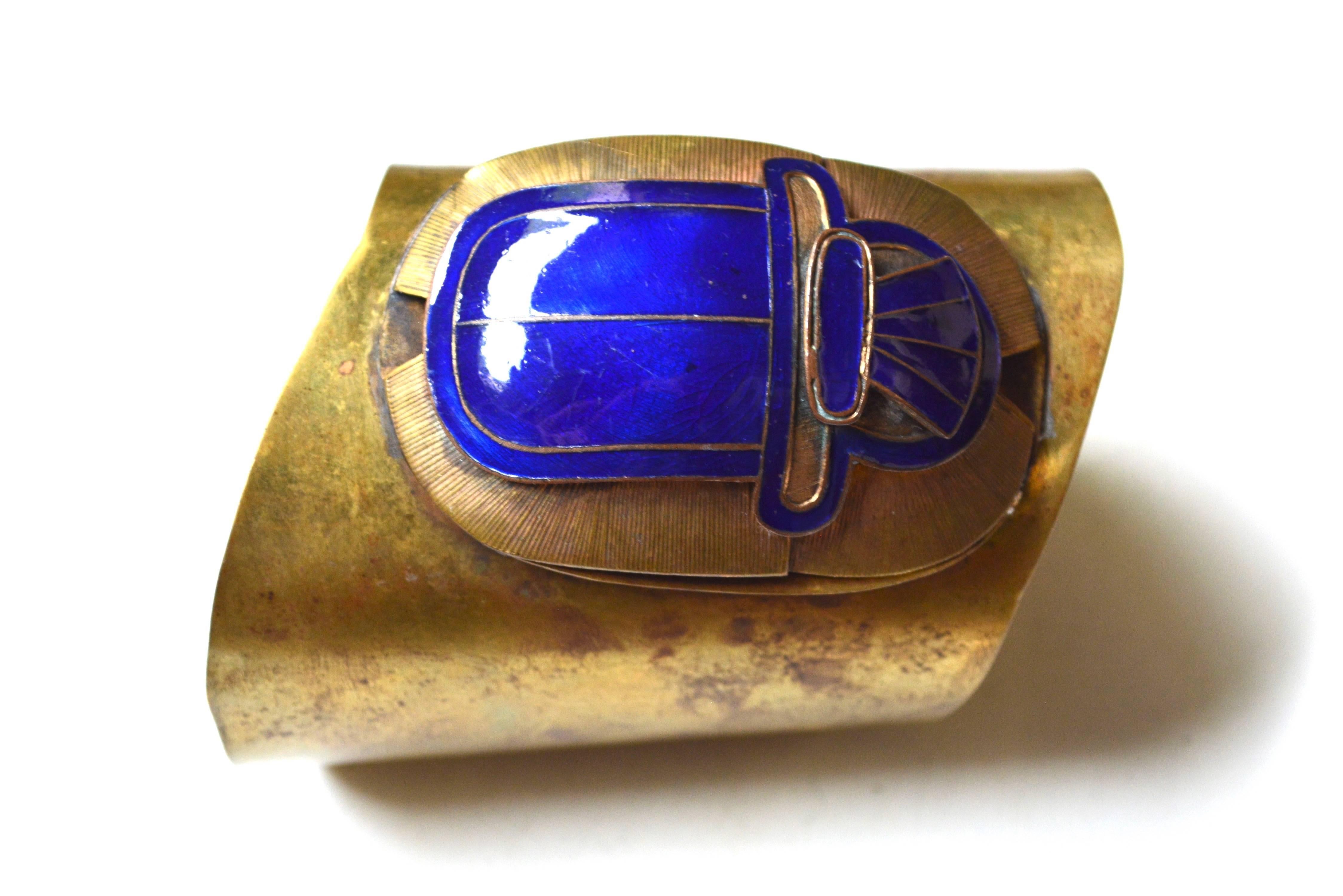 1920s art deco Egyptian revival at its best! The scarab is a gorgeous blue and huge. The metal appears to be brass. From a European collection of jewelry. The cuff at the widest part measures 3" wide and sort of wraps with an initial opening of