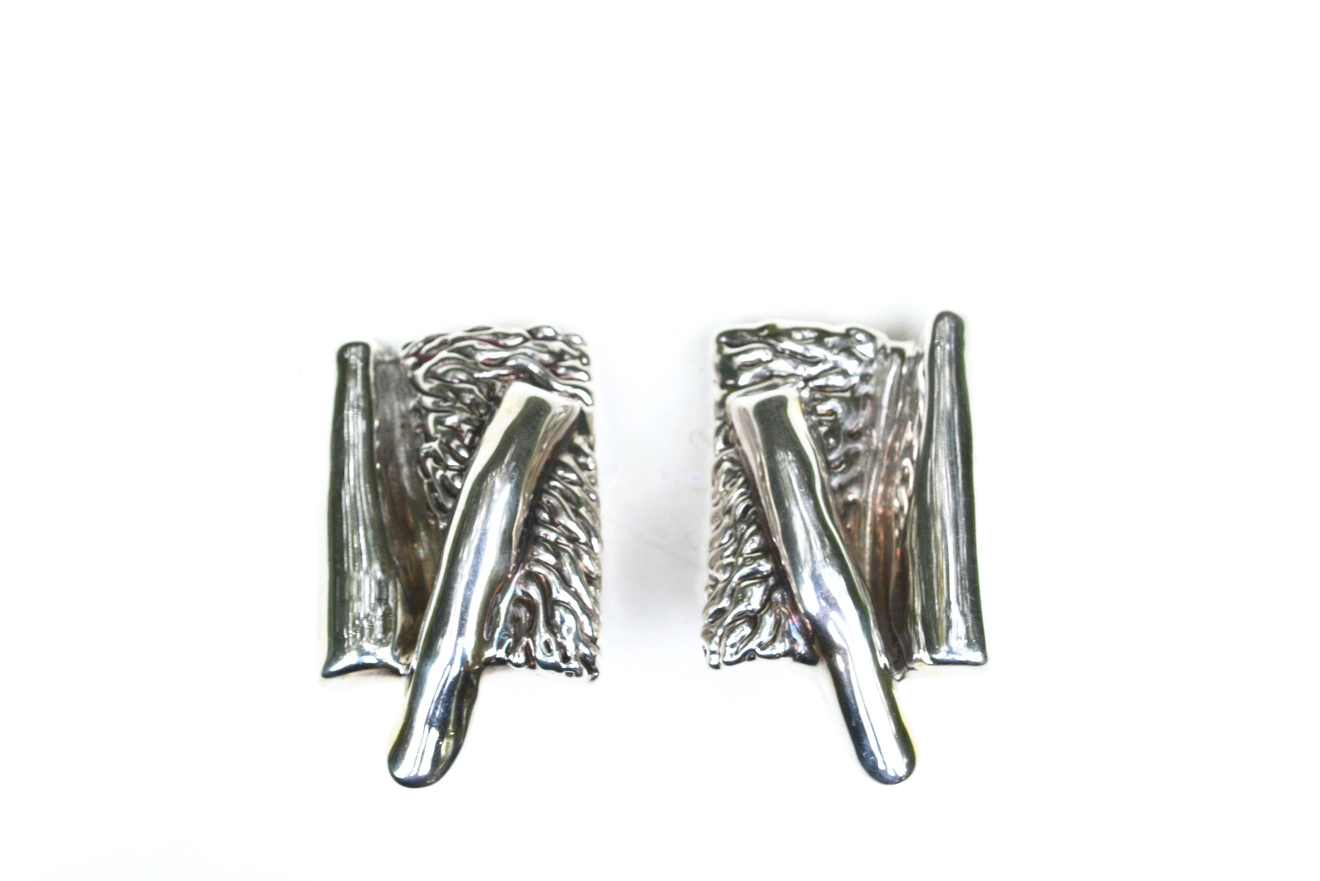 Signed 1980s sterling textured abstract oversized clip on earrings.  Possible Mexican mark, illegible. Hollow construction, comfortable weight. 