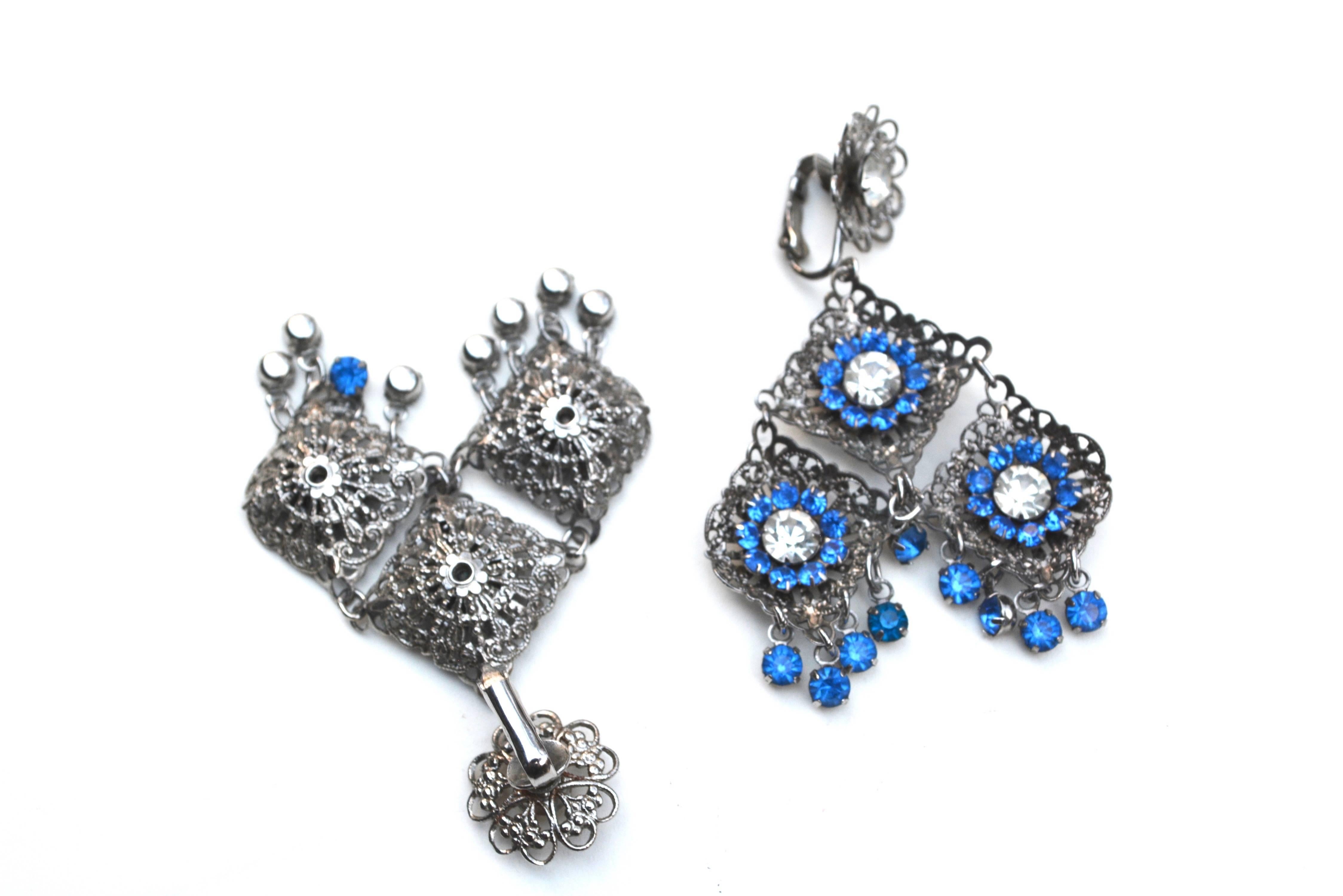 Vintage unsigned silver metal and blue rhinestone earrings, circa 1960s. Great movement and scale.  About 2.75" long x 2" wide. 