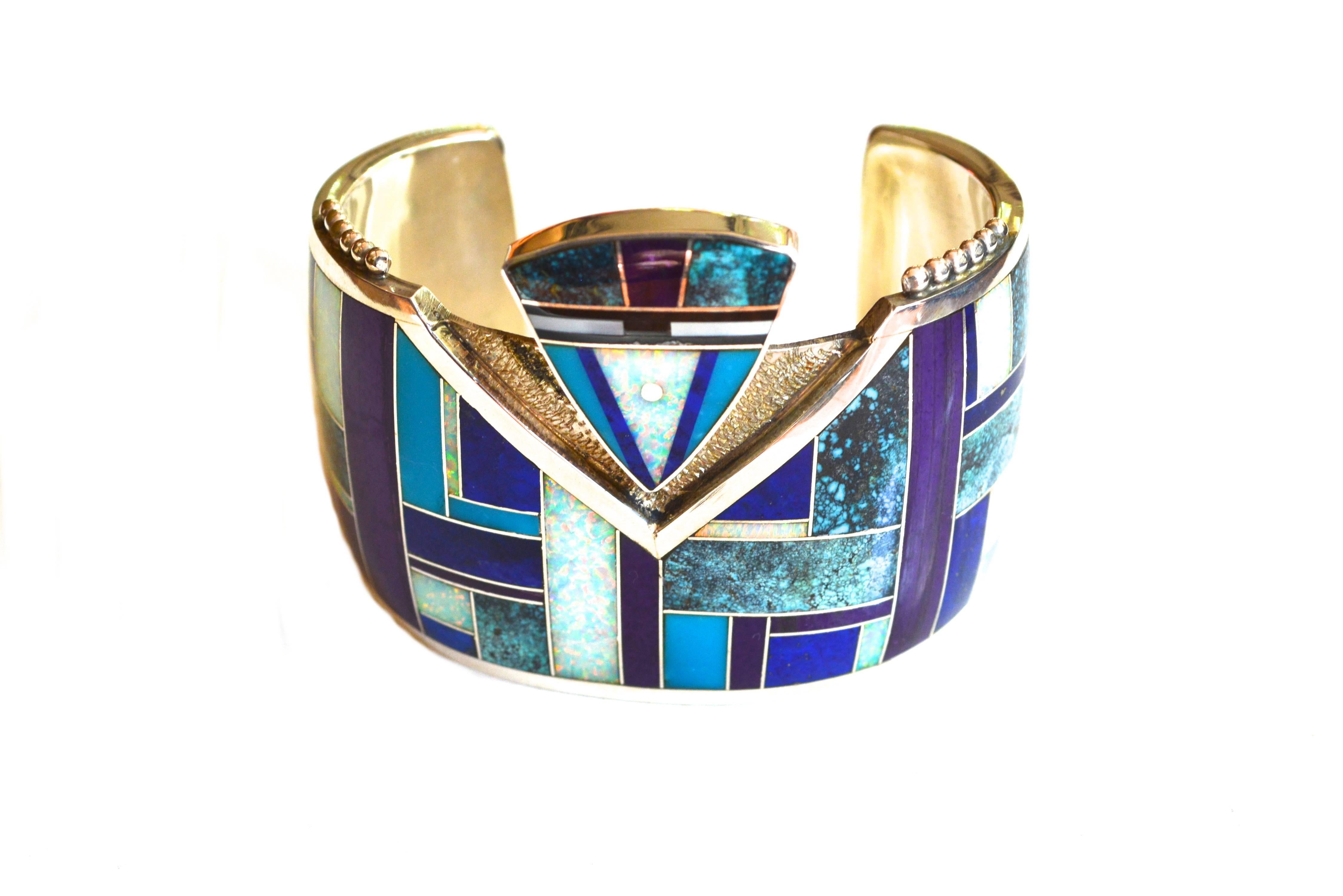 Vintage signed Yazzie sterling and turquoise cuff featuring various other skillfully inlaid stones such as opal.  Modernist abstract reference to the Yei or a figural style piece. 

The bracelet is 7" in circumference and has a 1.5"