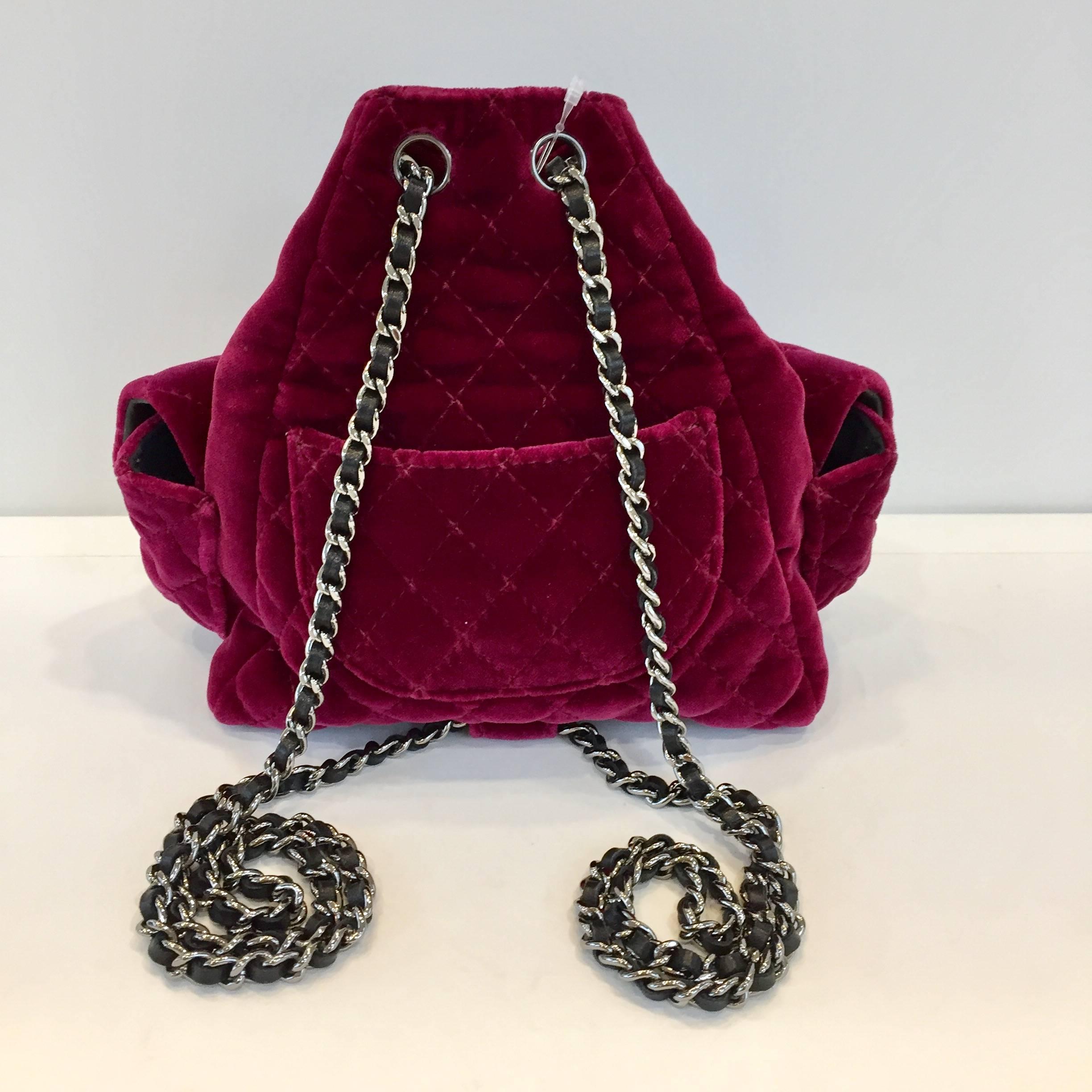 Stunning cherry velvet backpack by Chanel featuring two chain shoulderstraps and a front zipper, embellished with a logo charm. Two logo pockets to the front. 
Its conditions are perfect and its meaurements are: 17 cm x 20 cm x 12 cm. It comes with