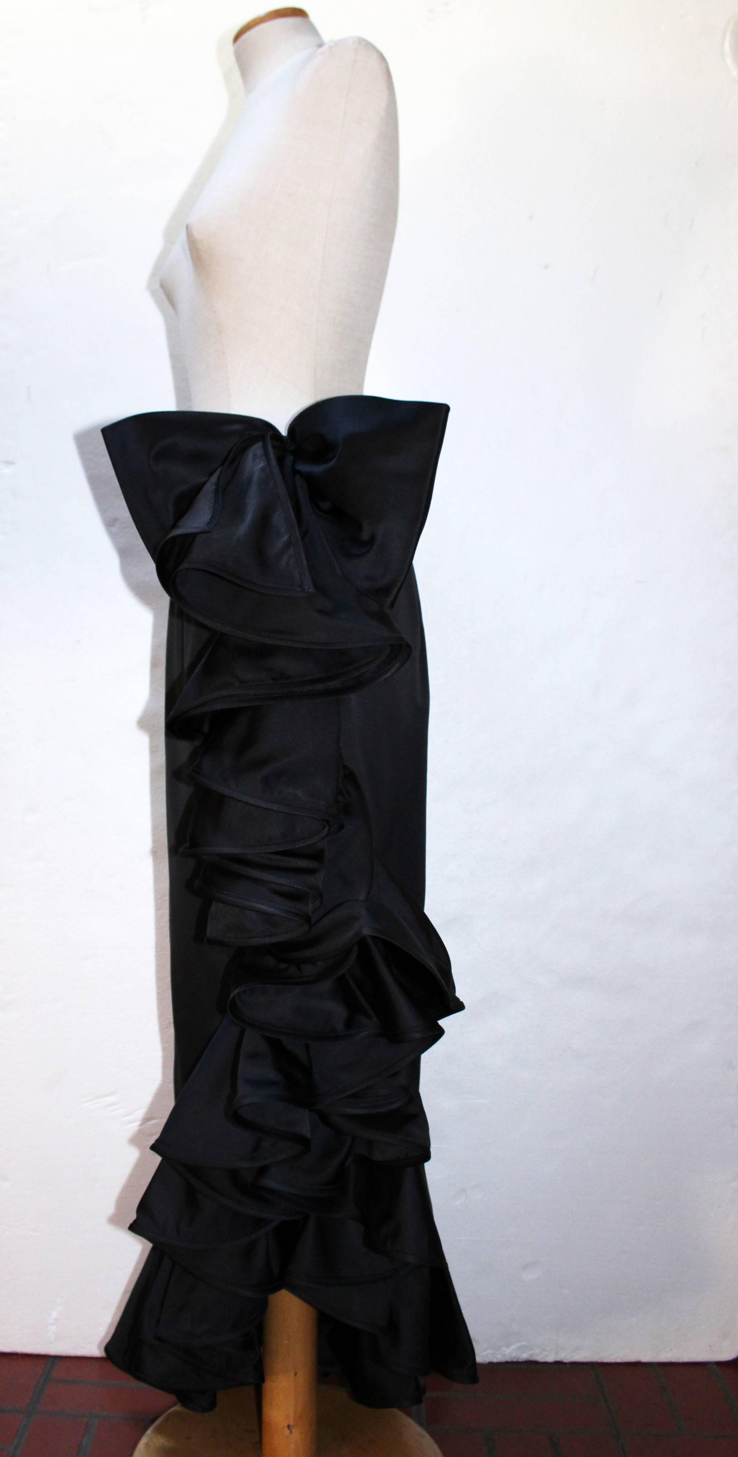 Valentino Night black draped skirt featuring an asymmetric style and a velvet bow belt. Side zipper closure. Fully lined. Silk-blend fabric.
Made in Italy and in excellent conditions. 
Size 42 IT.