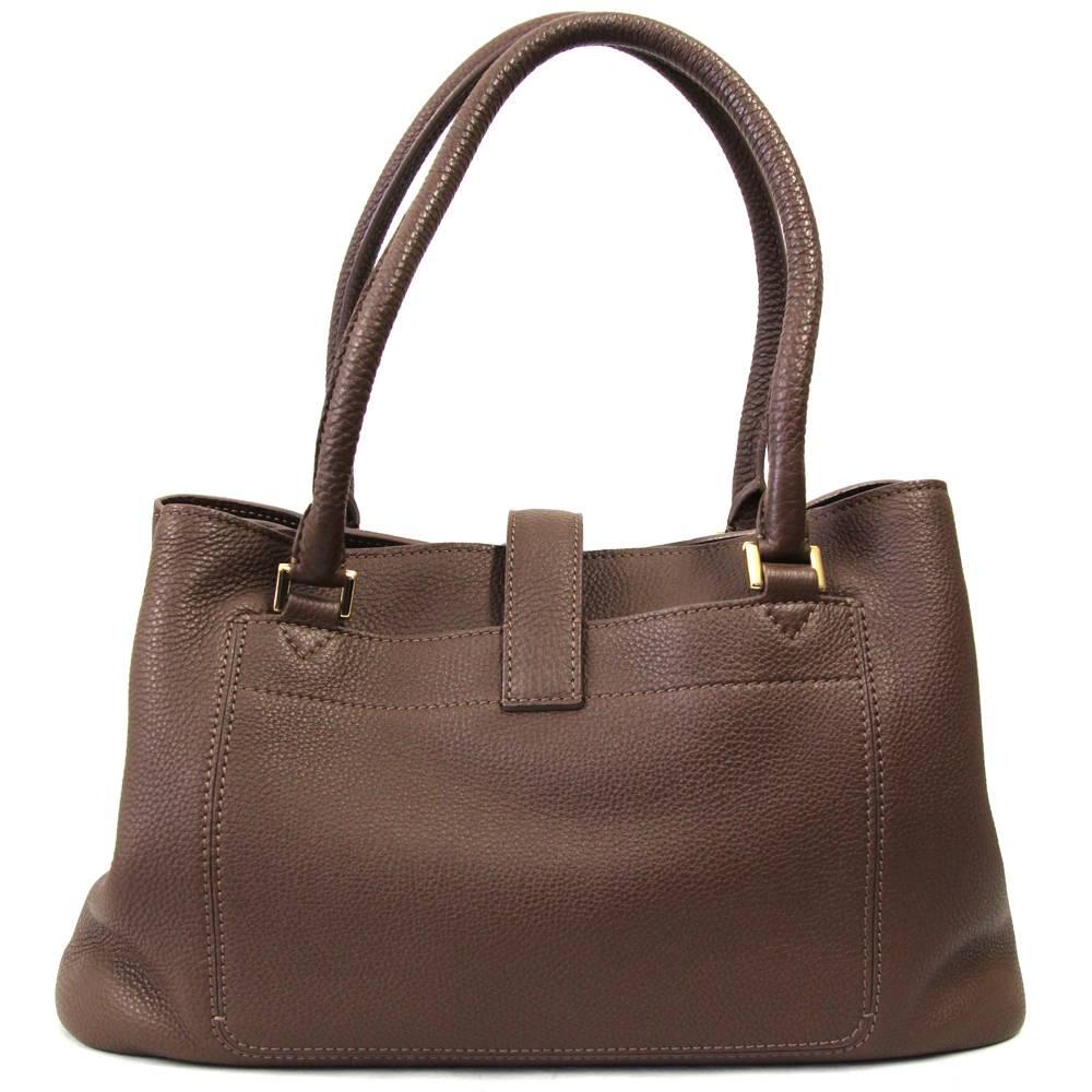 This super smart and stylish 2000s Loro Piana bag is made of smooth brown leather and features two internal compartments, two zip pockets, three internal and two external pockets. Interlocking closure and precious logo charms hanging from one of the