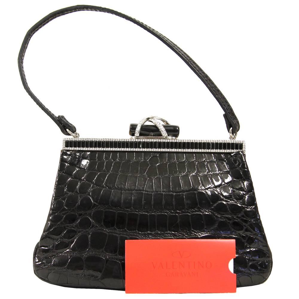 Stunning little piece of extreme elegance, this Valentino clutch is made of luxury, soft crocodile leather. It features super chic details with plenty of shiny rhinestones poured over the silver hardware. Special mention to the elegant lock.