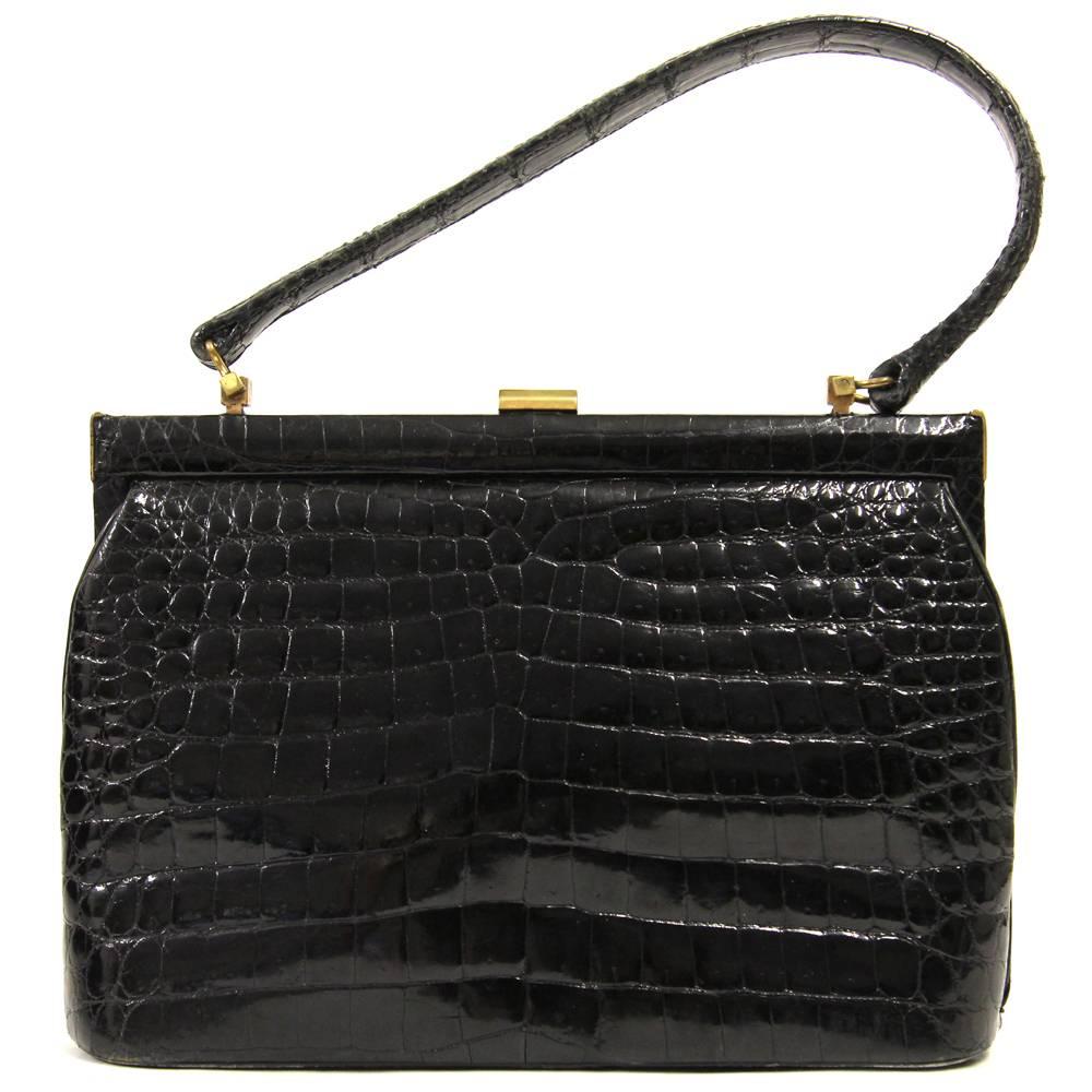 Elegant Gucci purse in luxurious black crocodile leather dating back to the 1950s. Features a snap lock and leather interiors including one zip pocket and two standard pockets. Good conditions.
Please note this item cannot be shipped outside the
