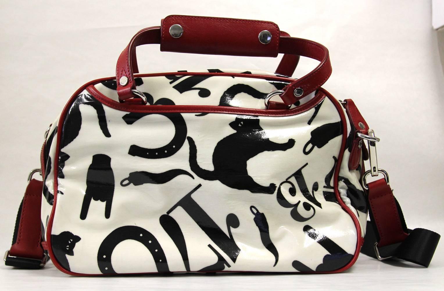 Fun and playful Moschino handbag in white laminated fabric with a print of symbols of superstition and red leather edges. Features a removable strap, zip closure, feet, two outside pockets and two inside pockets. Good conditions.

Measurements:
33