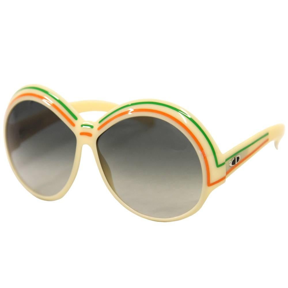 Rétro Christian Dior sunglasses from the 1970s with beautiful round shape. Made of white acetate with green and orange stripes. Good conditions.

Please note this item cannot be shipped to the US.

Width: 15 cm