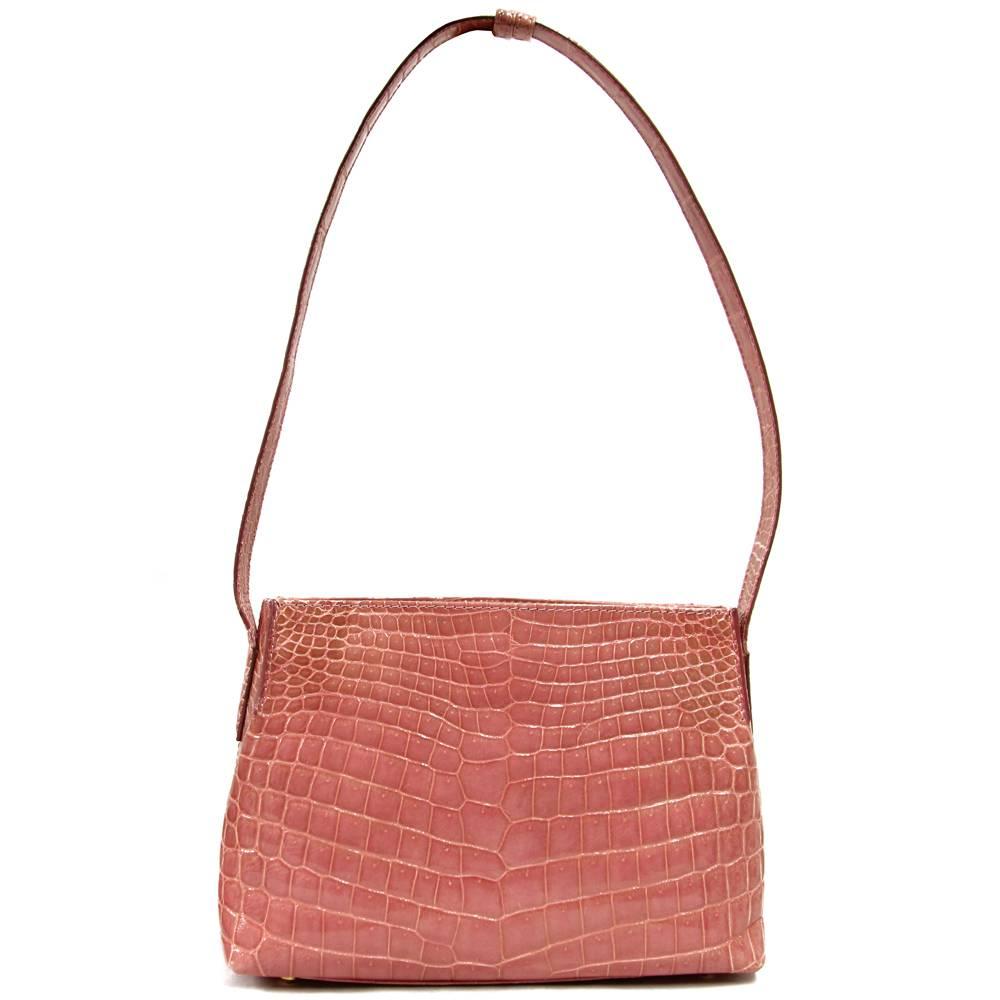 Super cute Dotti shoulder bag in pink crocodile leather. Features a perfect green suede lining and a soft black mini pouch in the inside. Handle is adjustable and can be worn both by hand and on the shoulder. Very good conditions.
Please note this